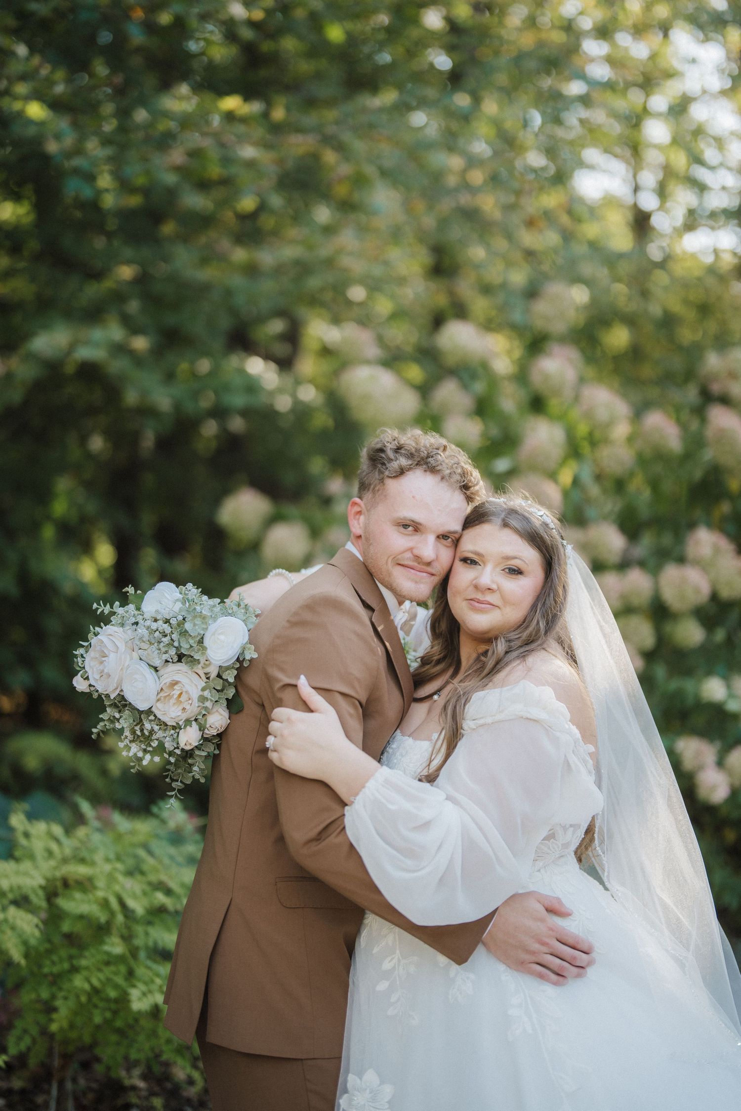 A romantic wedding portrait series in a garden setting with soft natural lighting and white floral bouquet details.