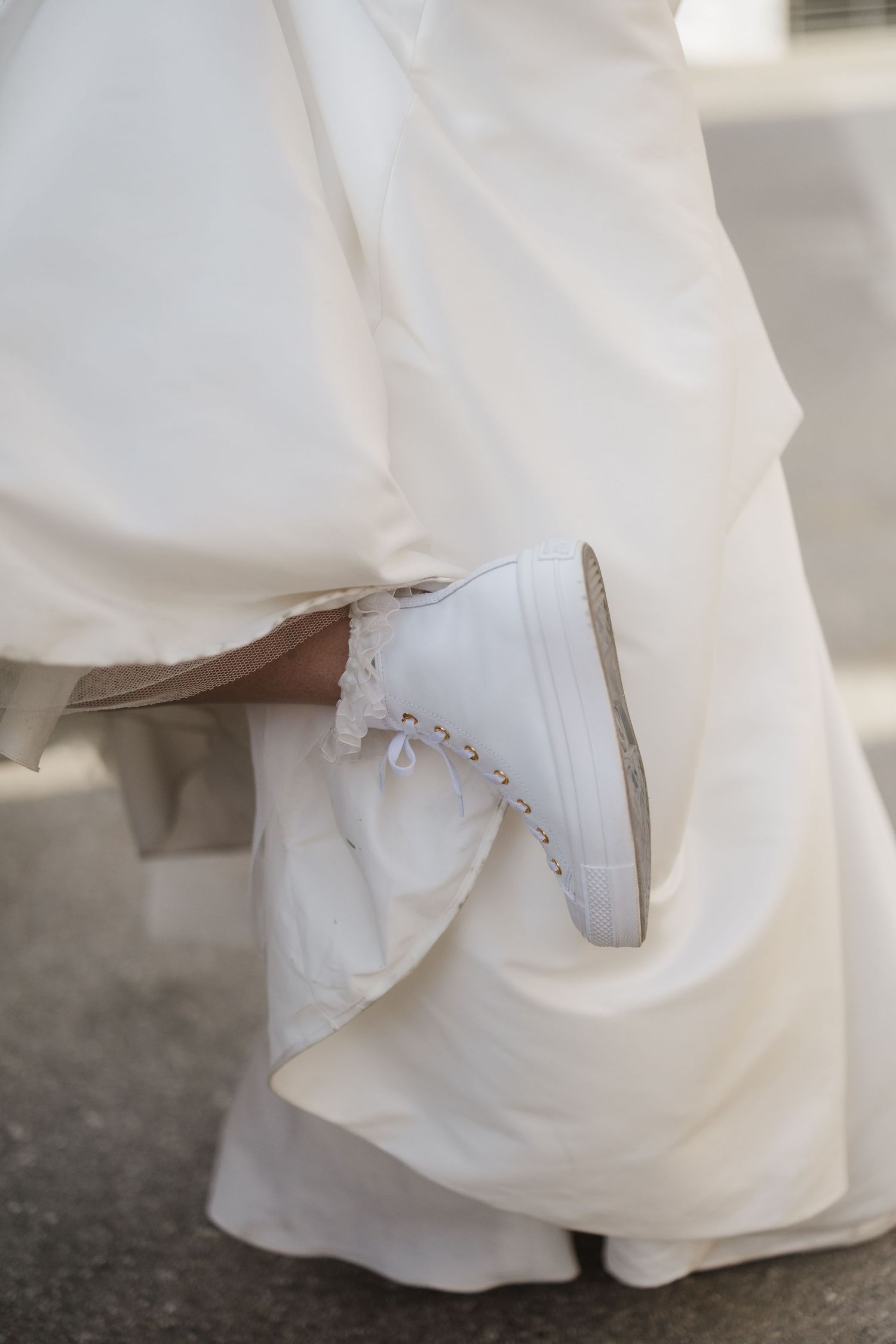 Close-up view of a white wedding dress hem and underskirt details.