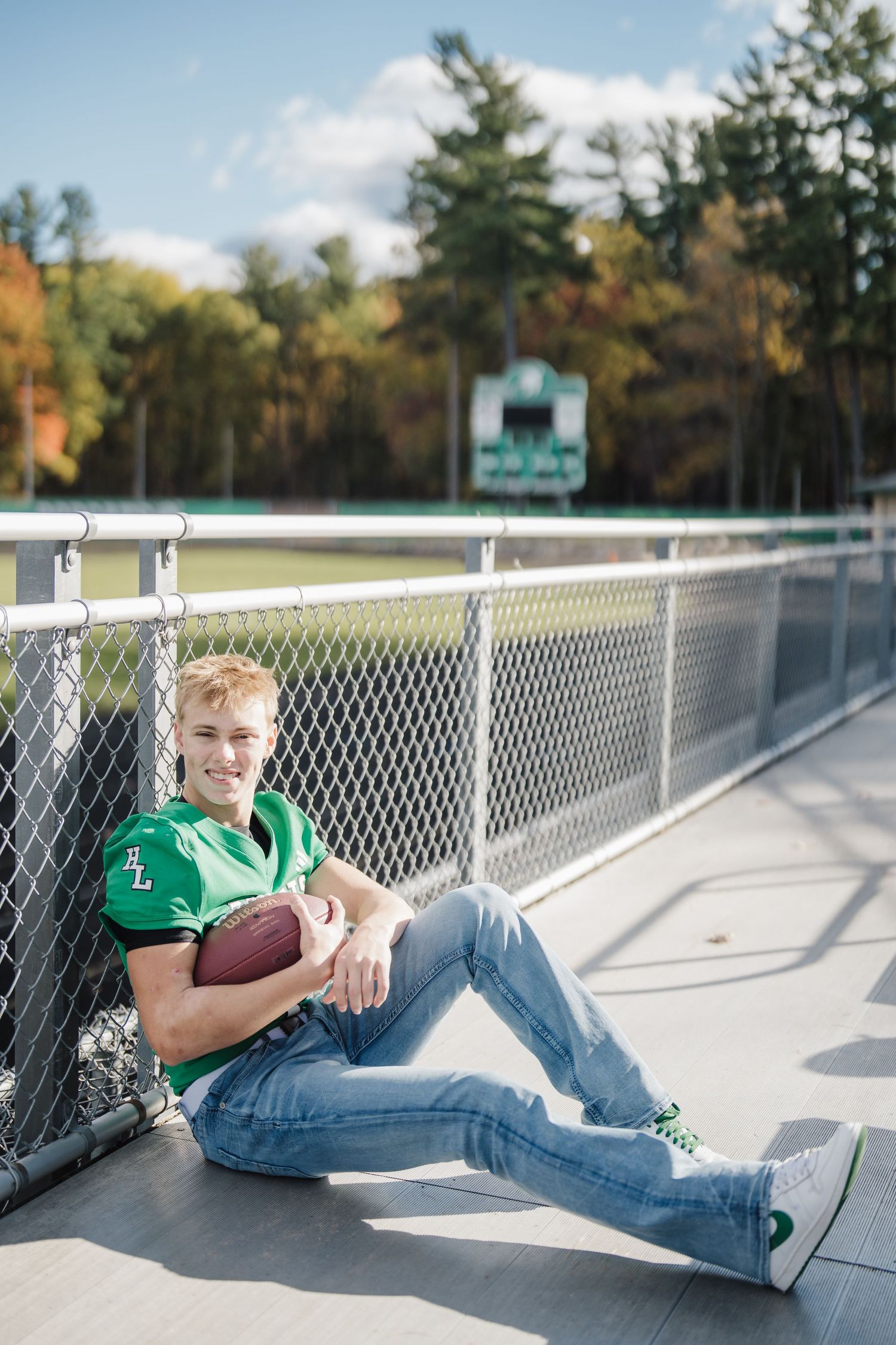 Sports-themed portraits of someone in a green jersey relaxing against a chain-link fence with a football.