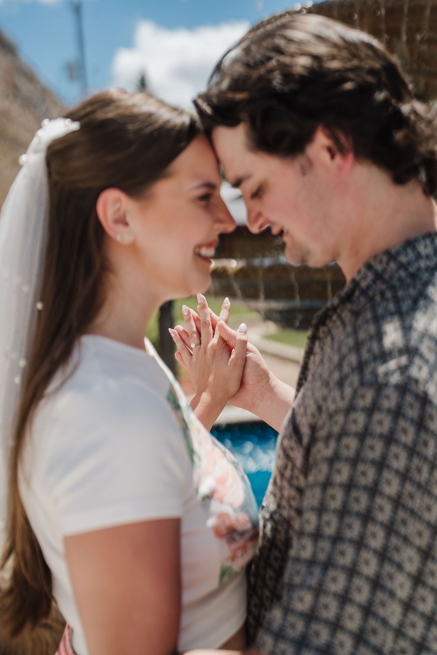 A romantic moment between a couple as they hold hands and lean in close together, smiling with joy.