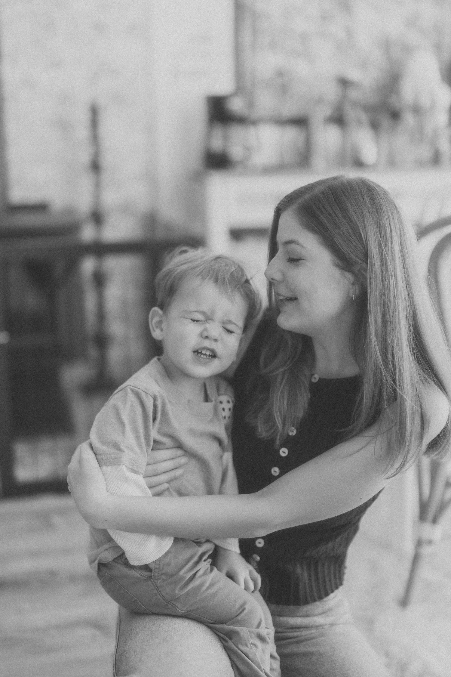A series of black and white photos showing tender moments between parent and child in candid poses.