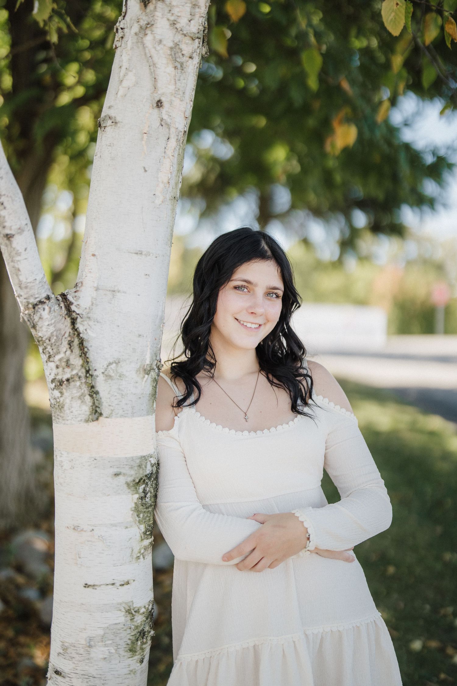 White birch trees frame a dreamy outdoor portrait session on a sunny fall day.
