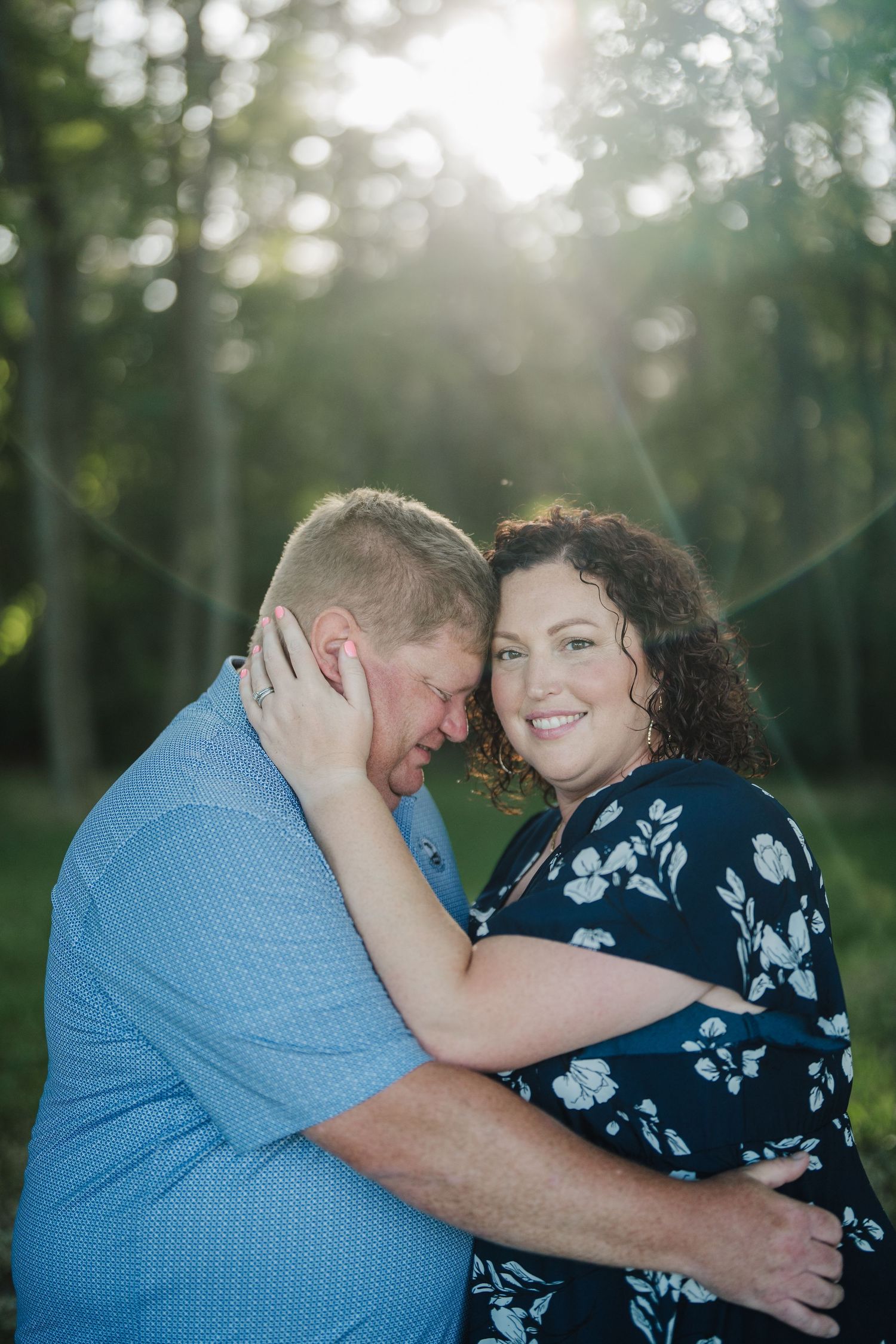A romantic outdoor photoshoot sequence showing tender moments between a couple in blue and navy floral outfits.