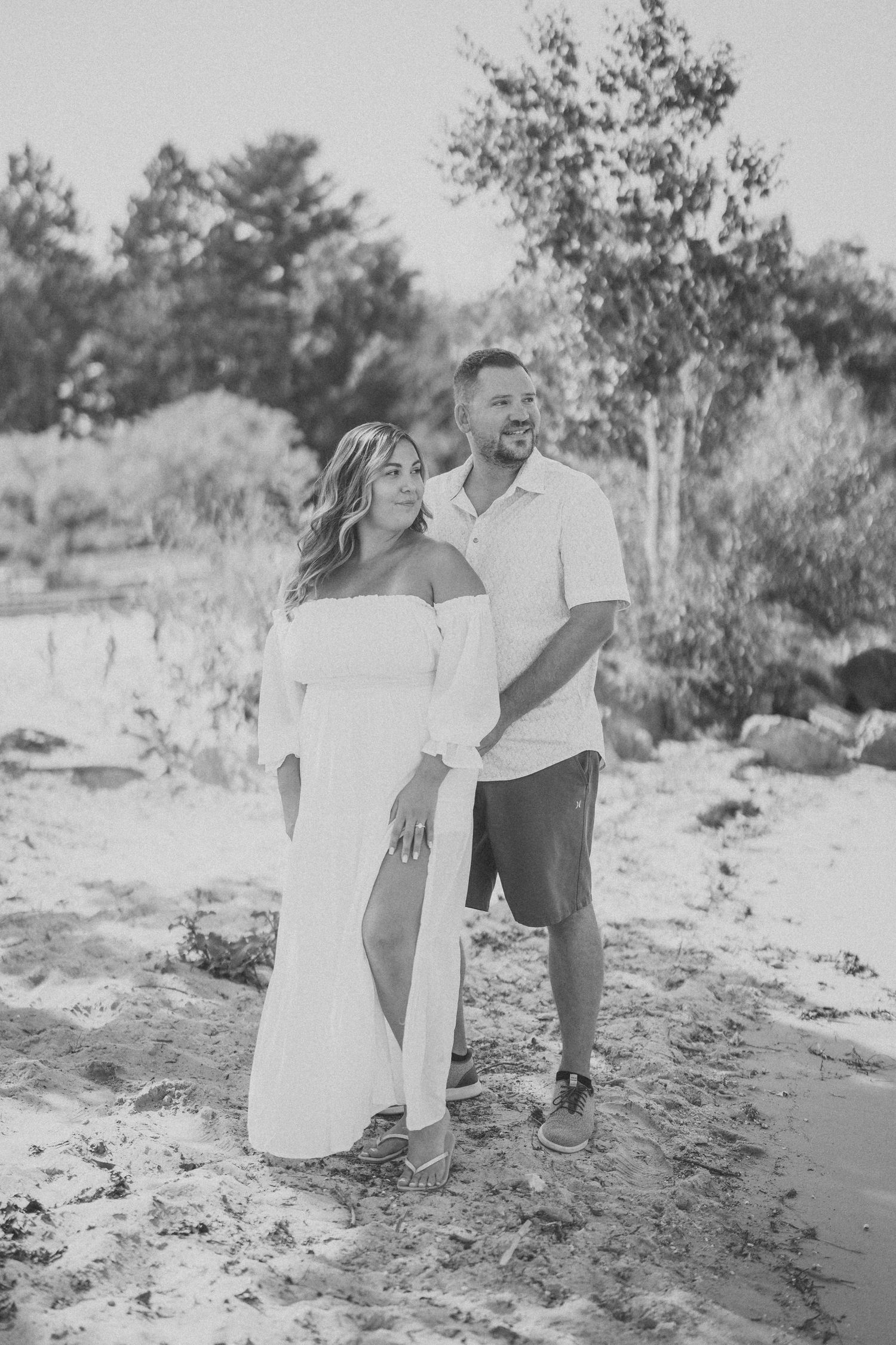 A romantic black and white photo sequence shows a couple dancing playfully together on a sandy beach.