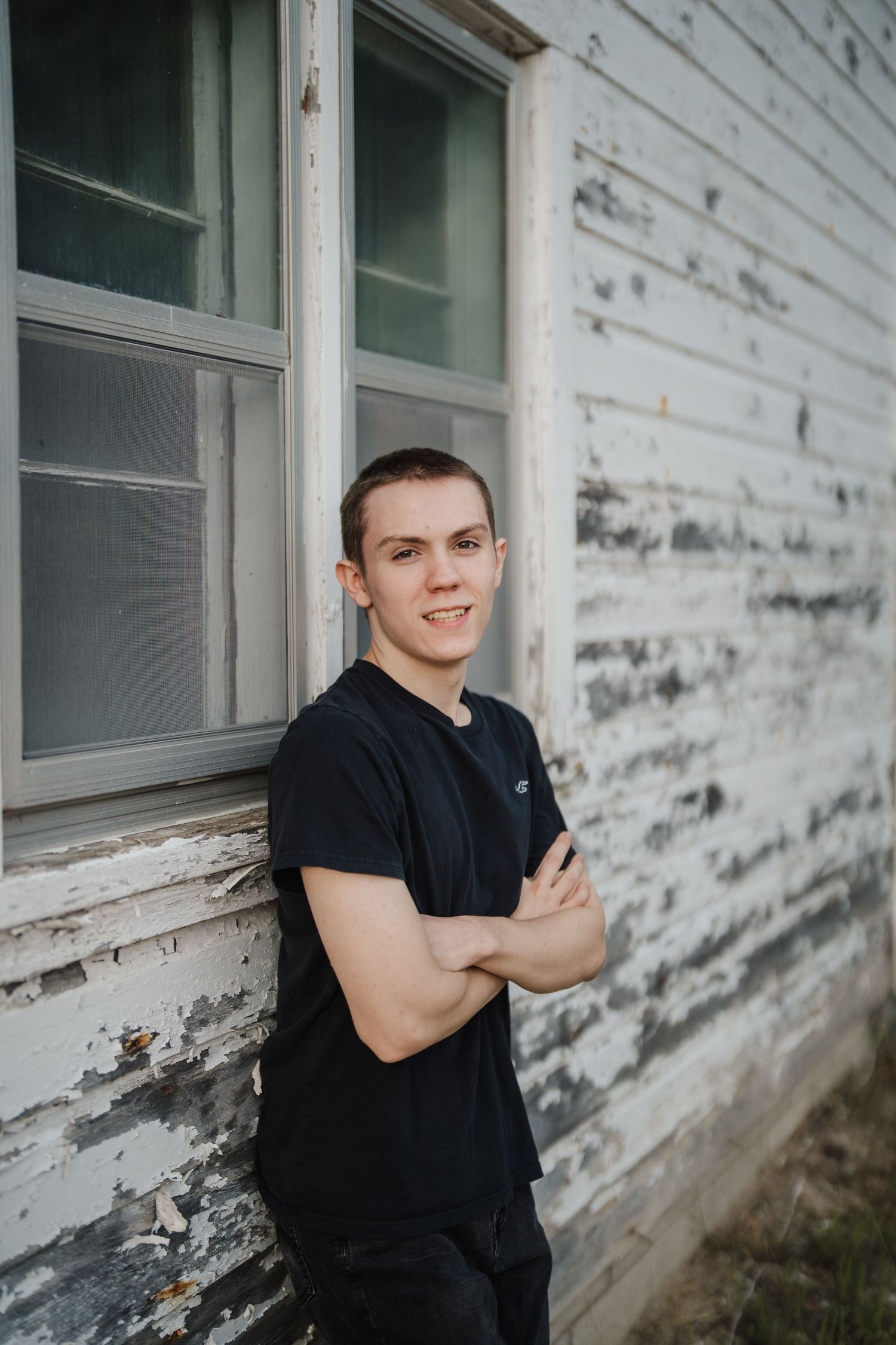 A series of four casual portraits taken against a weathered white building exterior with peeling paint.