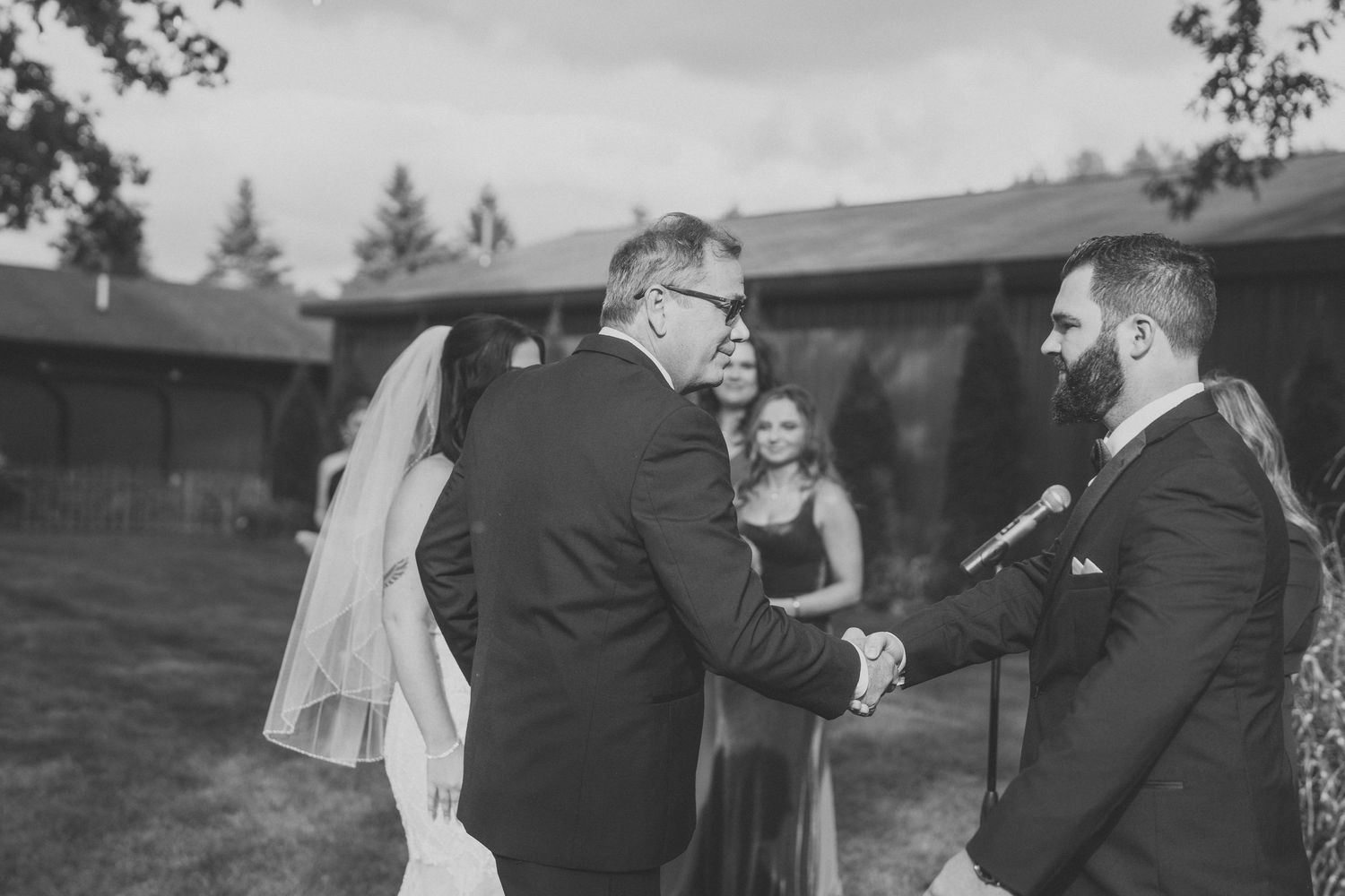 A series of black and white wedding photos showing intimate moments between couples during an outdoor celebration.