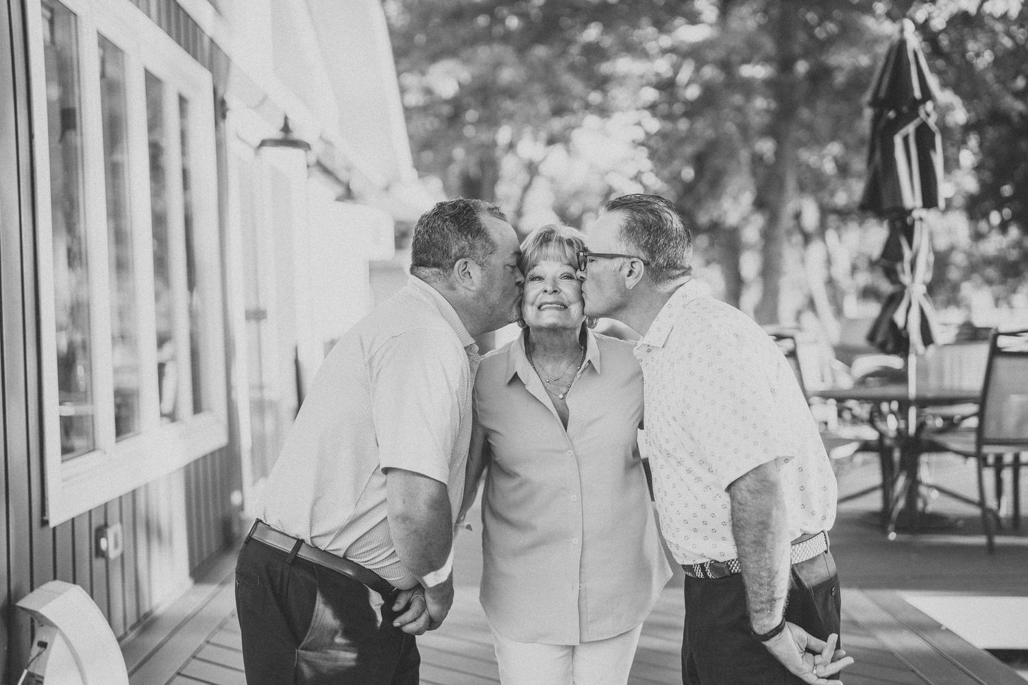 Black and white photo series showing candid moments at an outdoor wedding celebration.