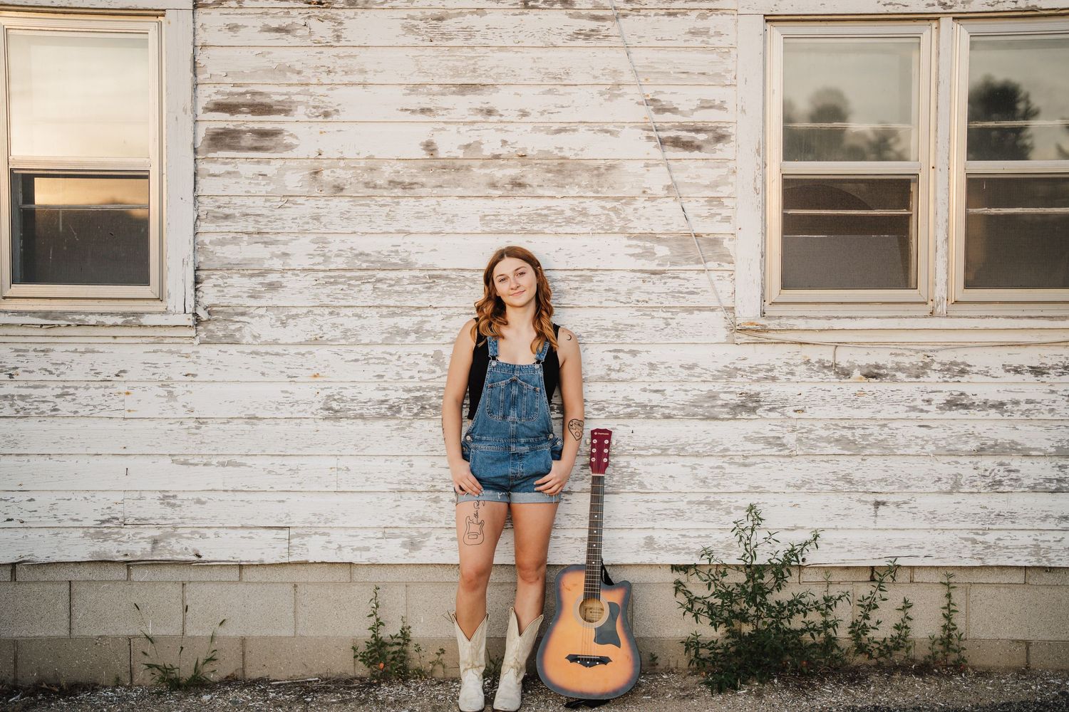 A series of portrait shots against a white weathered building with a guitar as a prop.