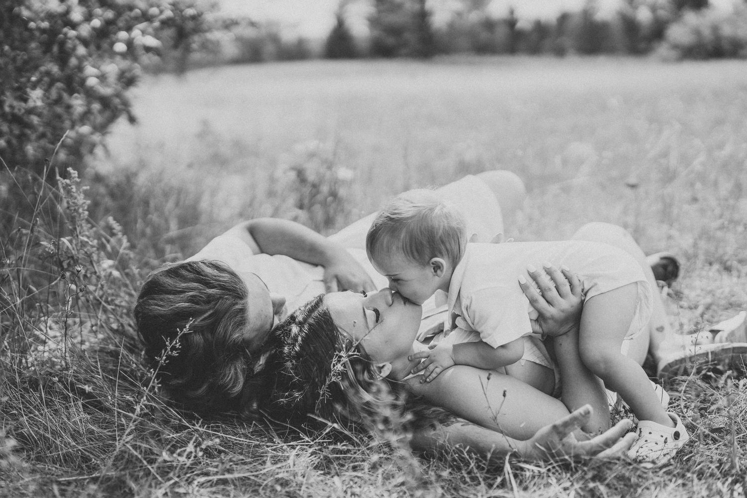 A black and white photo series shows a person lying in grass in different relaxed poses.