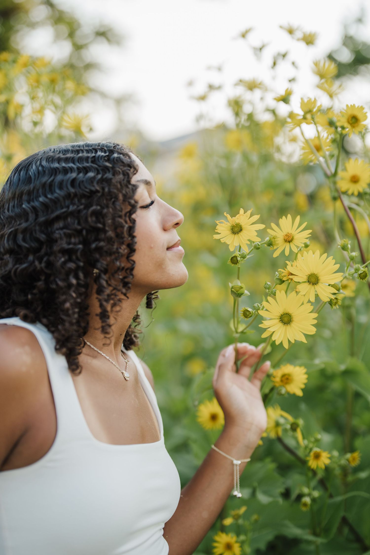Someone enjoying a peaceful moment among blooming yellow sunflowers on a bright summer day.