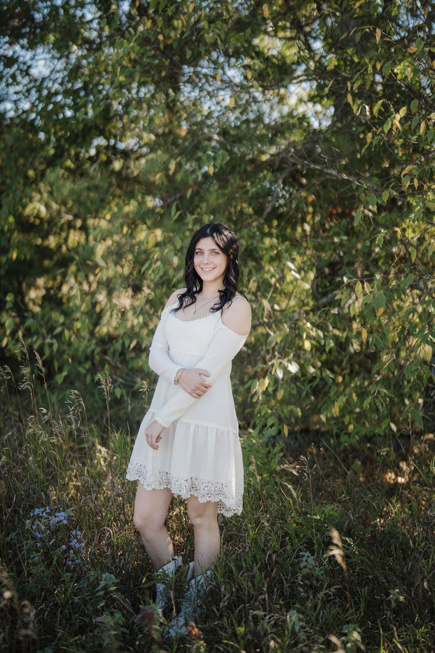 Romantic outdoor portrait session among lush green foliage and trees in natural sunlight.