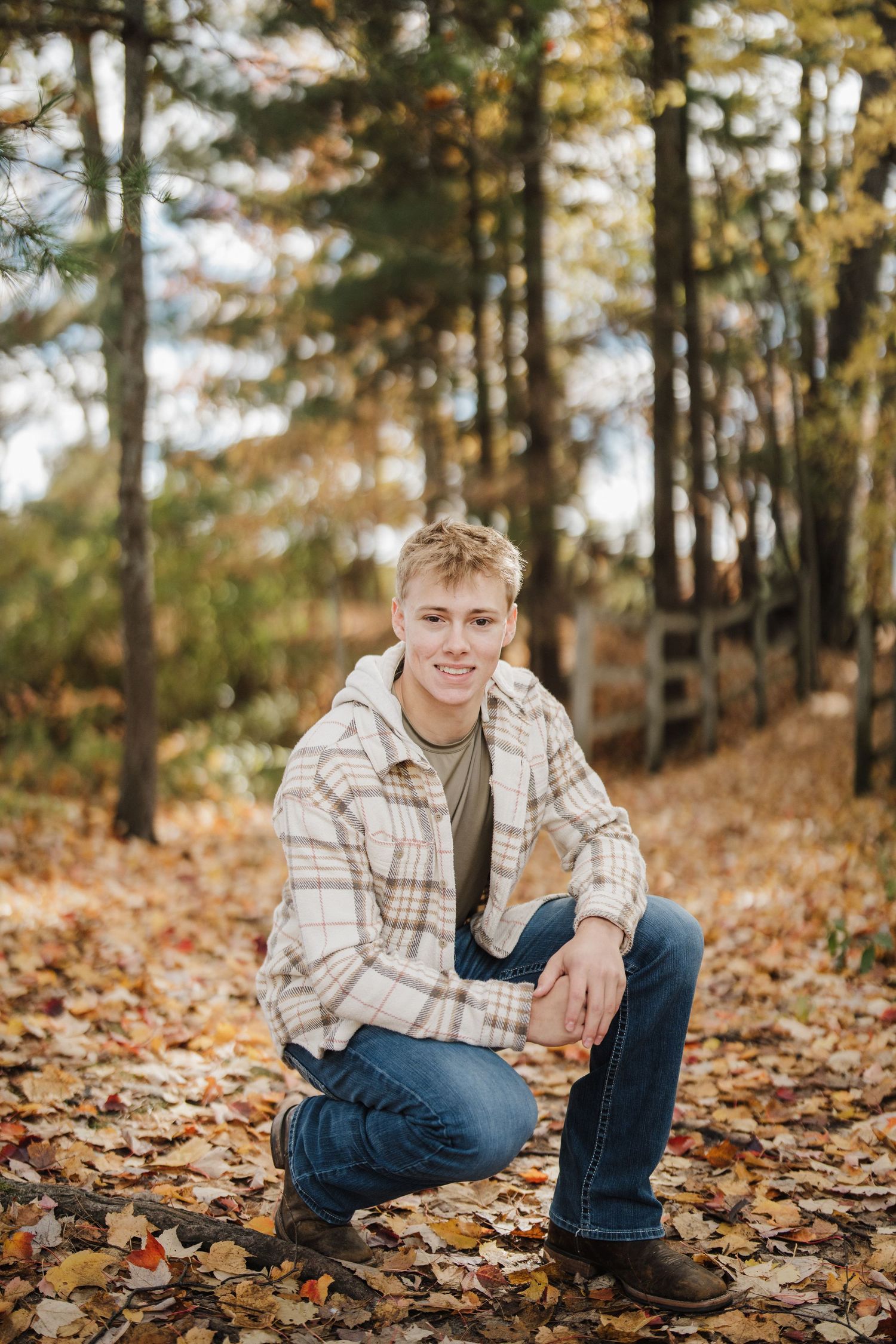 A series of autumn portraits showing someone sitting among fallen leaves in a wooded setting wearing plaid and jeans.
