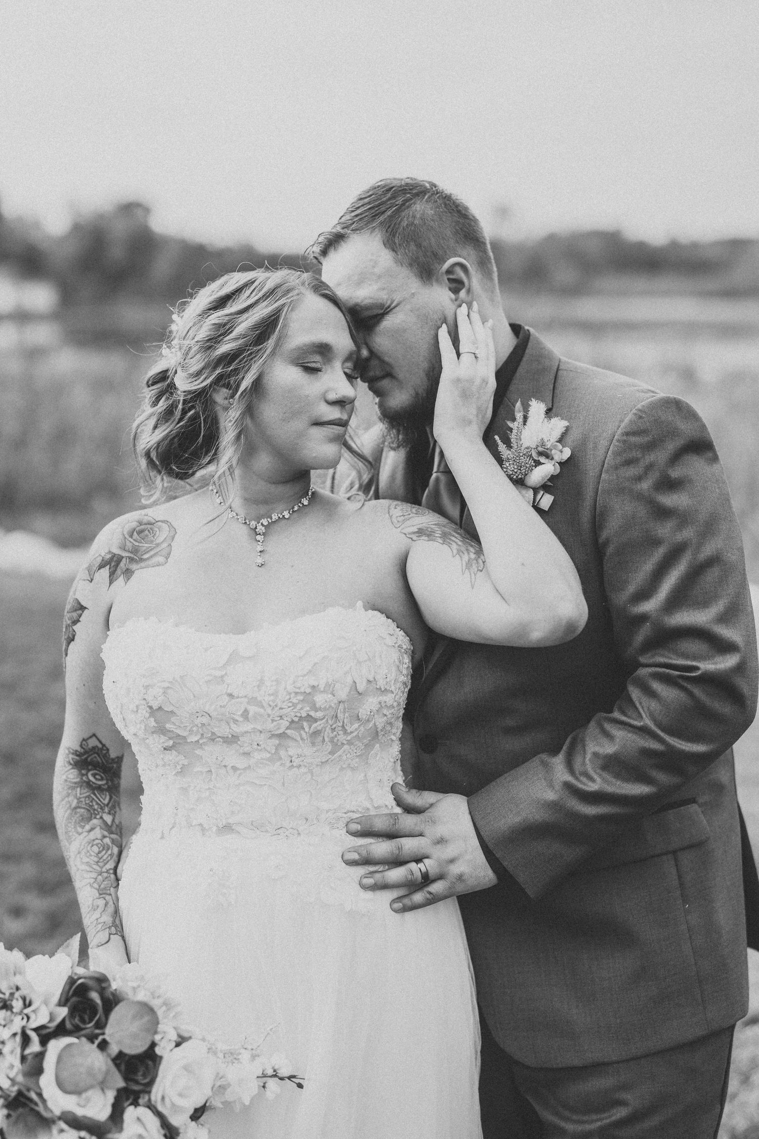 A romantic black and white wedding photo series showing tender moments between newlyweds in an outdoor setting.