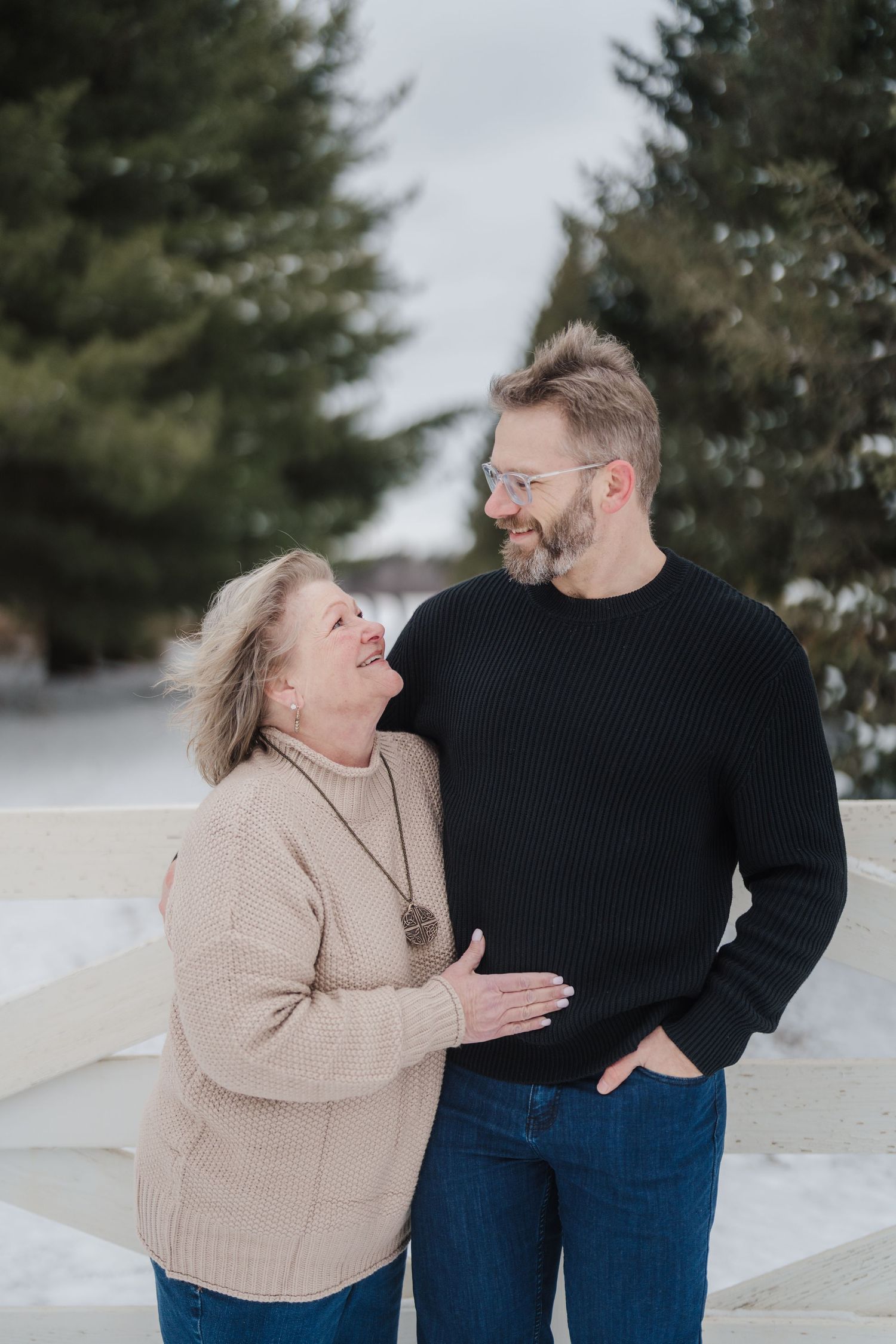 A heartwarming winter moment captured between two people sharing laughter in the snow.