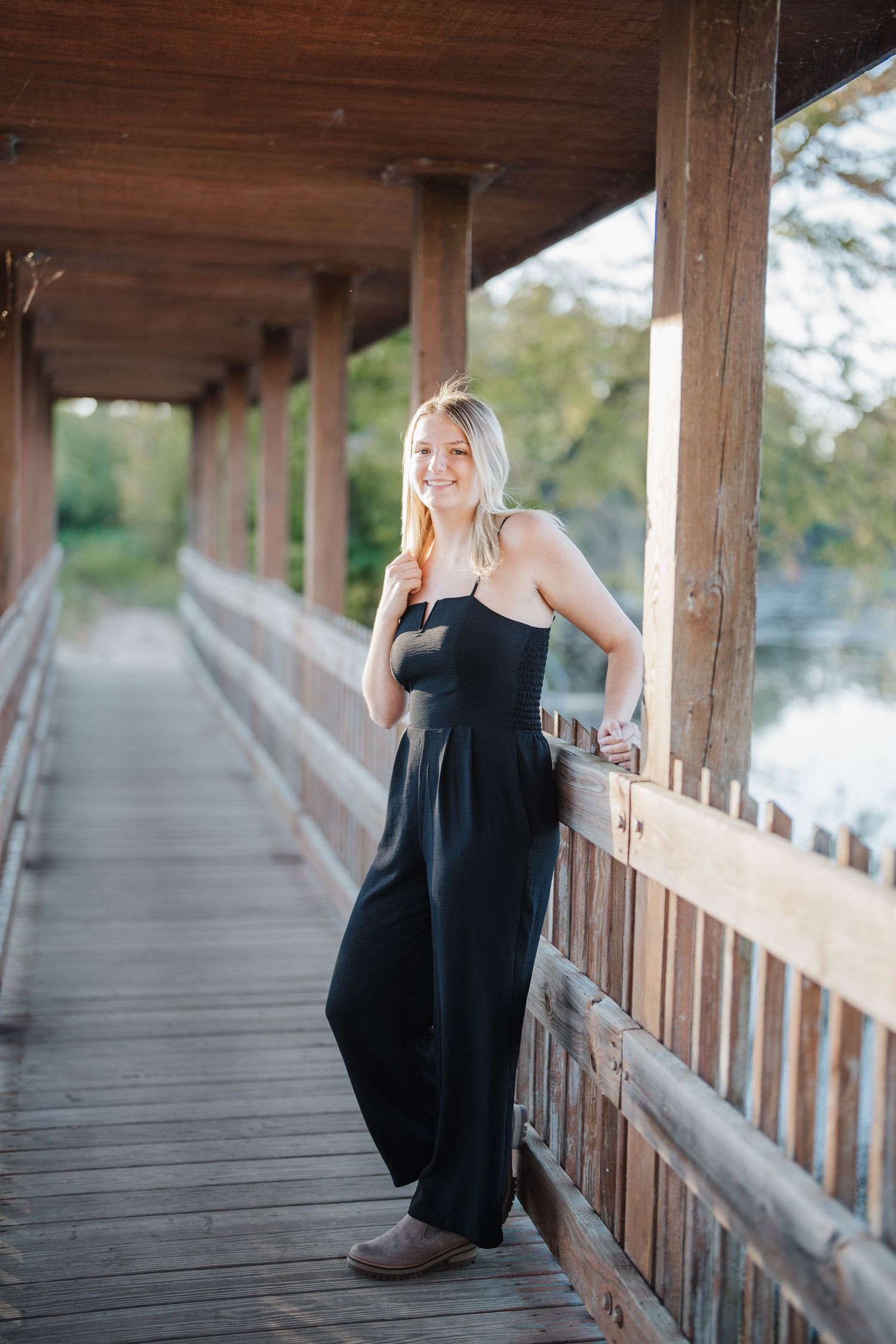 A series of photos on a covered wooden bridge walkway overlooking a peaceful lake during golden hour.
