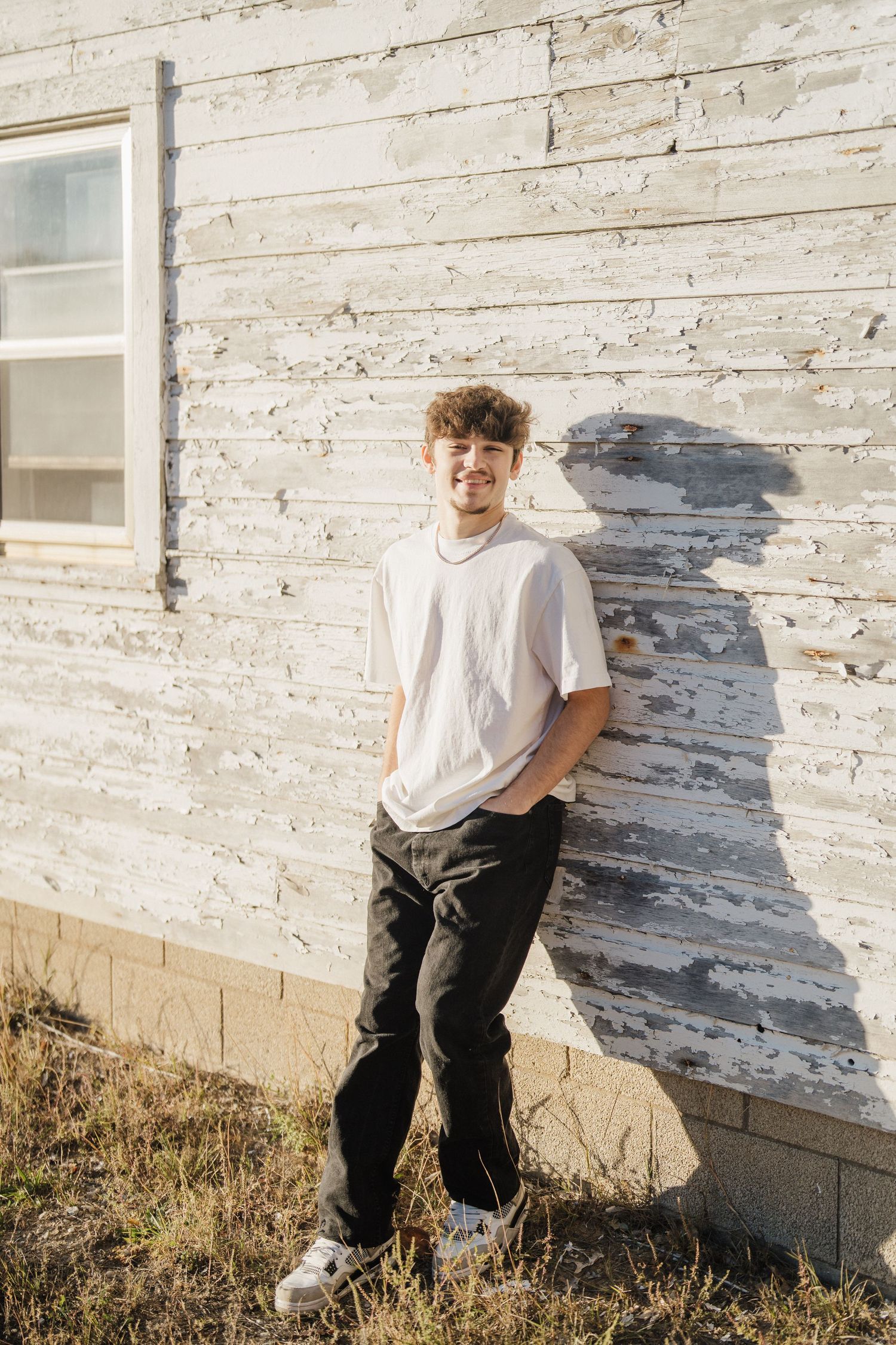 A casual outdoor photo series against a white painted wall showing shadows and natural lighting.