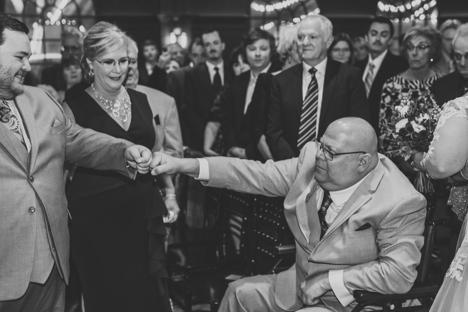 Black and white photo capturing a joyous dance moment at a wedding reception.