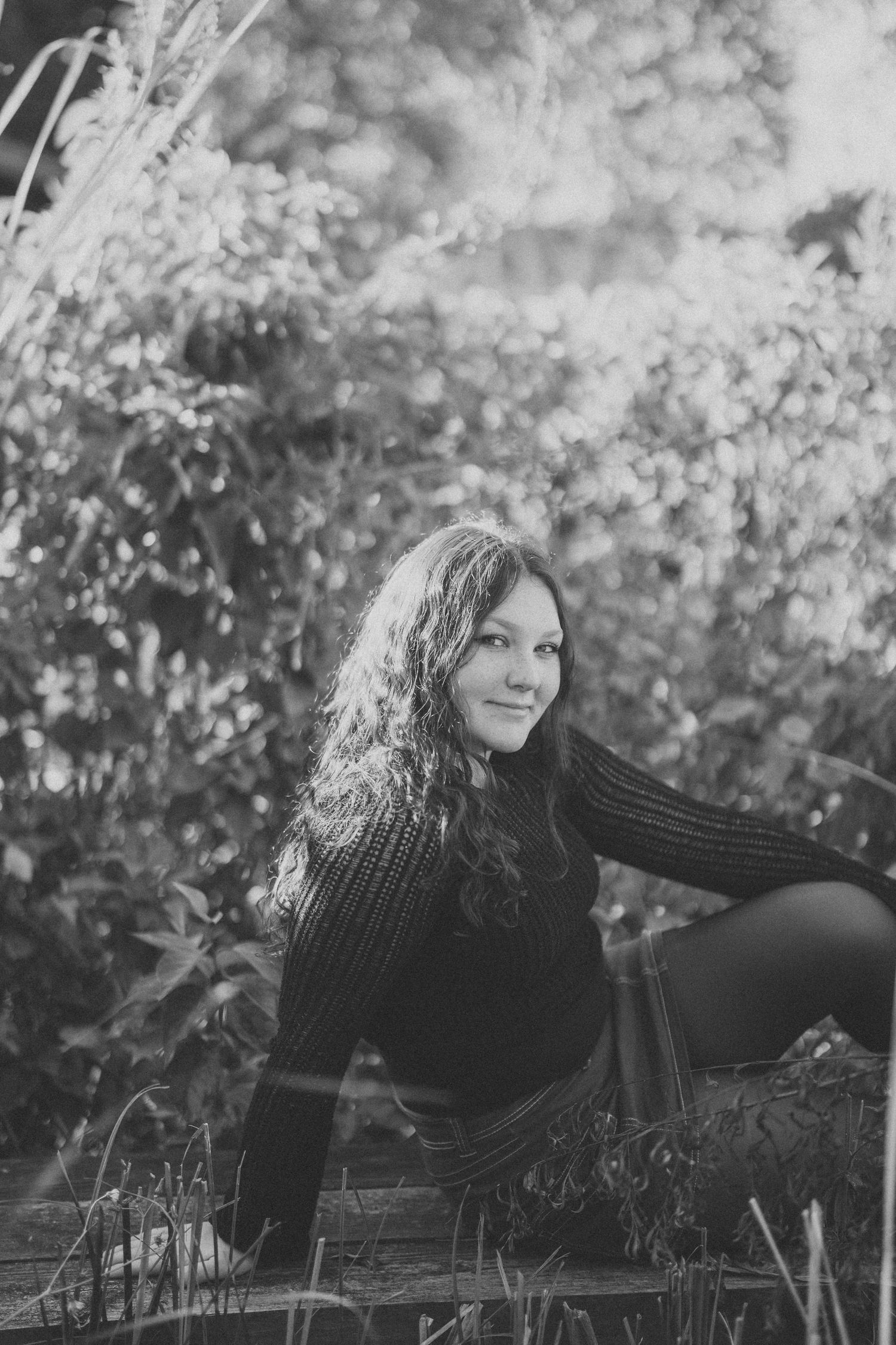 Monochrome outdoor portrait with dreamy bokeh background and natural lighting.