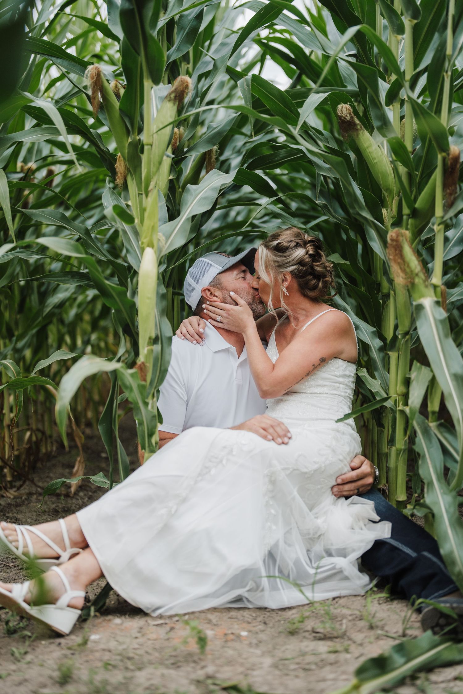 A romantic moment shared between a couple sitting among tall corn stalks.