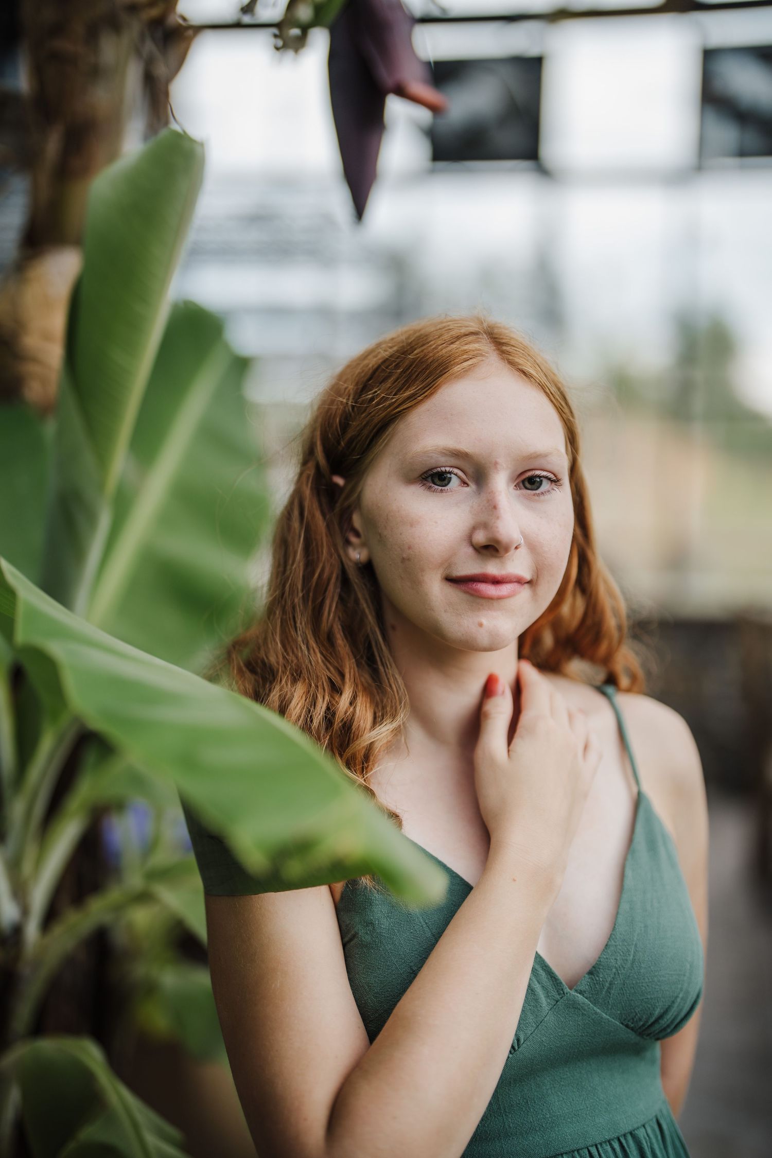 A series of expressive portraits in a greenhouse setting with green plants and natural lighting.