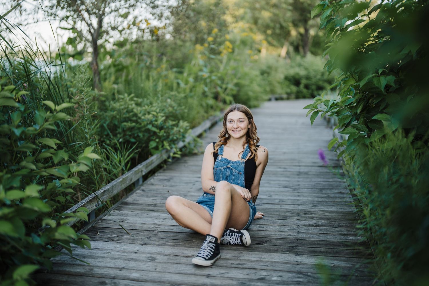 Casual lifestyle photos taken on a wooden boardwalk surrounded by lush green foliage.