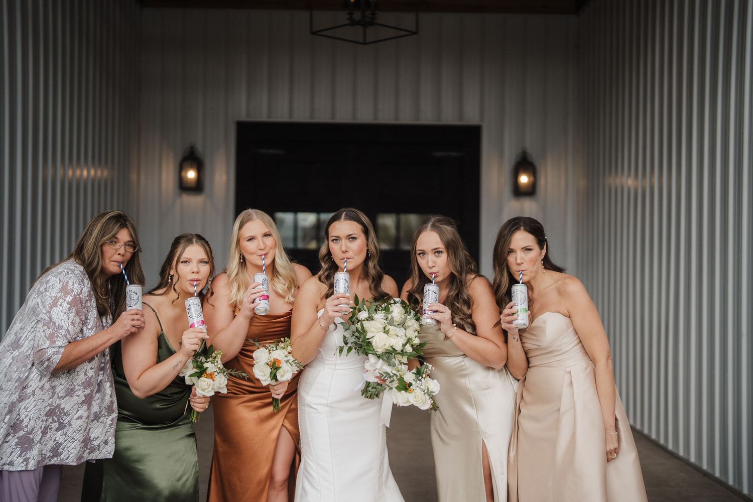 A group of bridesmaids in matching dresses share a celebratory moment with the bride at a wedding reception.