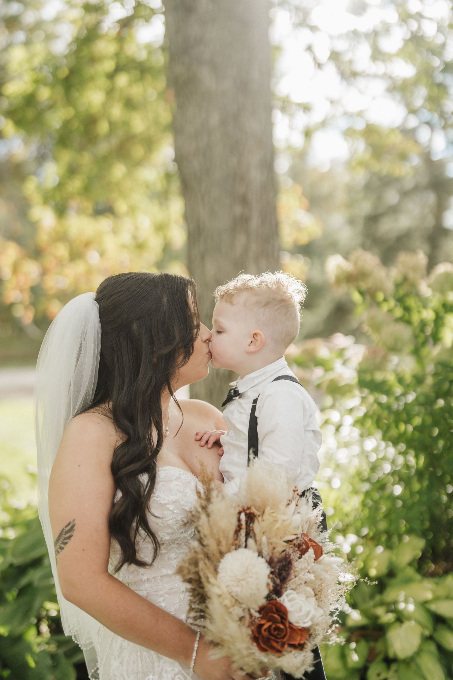A romantic wedding photo series showing tender moments with pampas grass bouquet in a sunlit garden setting.