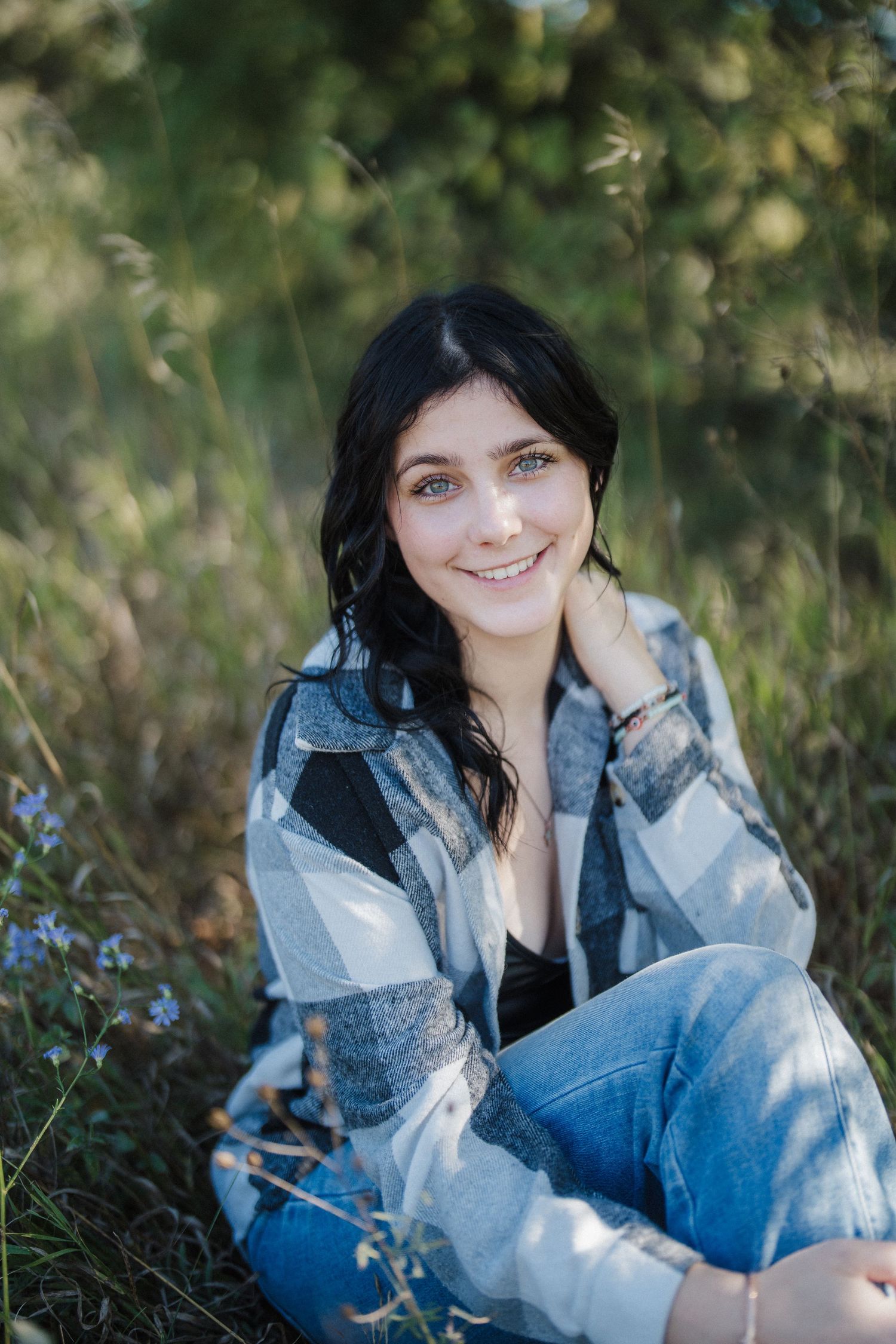 A collection of casual portrait photographs taken in a meadow with blue wildflowers and natural greenery.