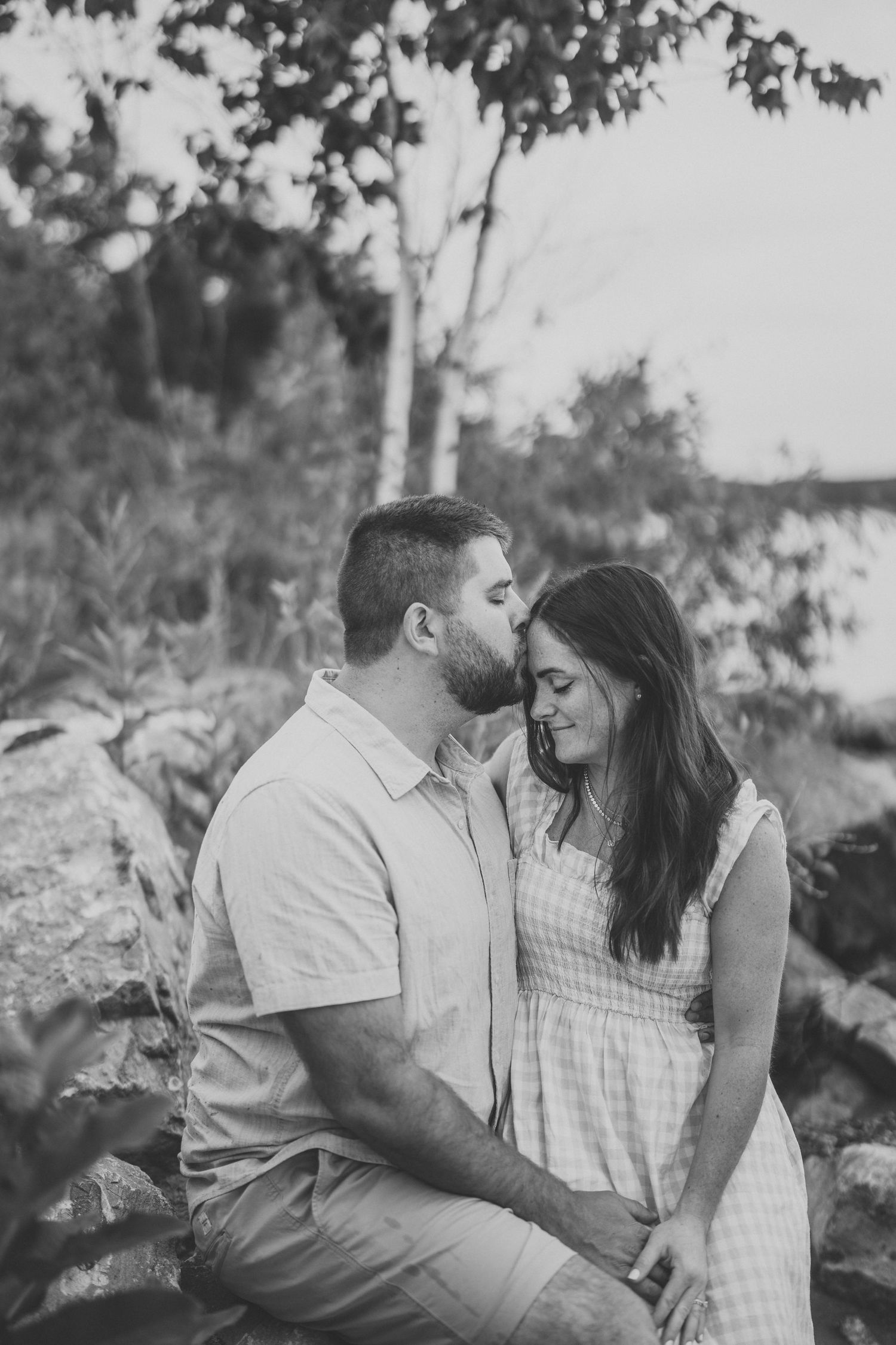 A romantic couple shares tender moments in a black and white photo series outdoors.
