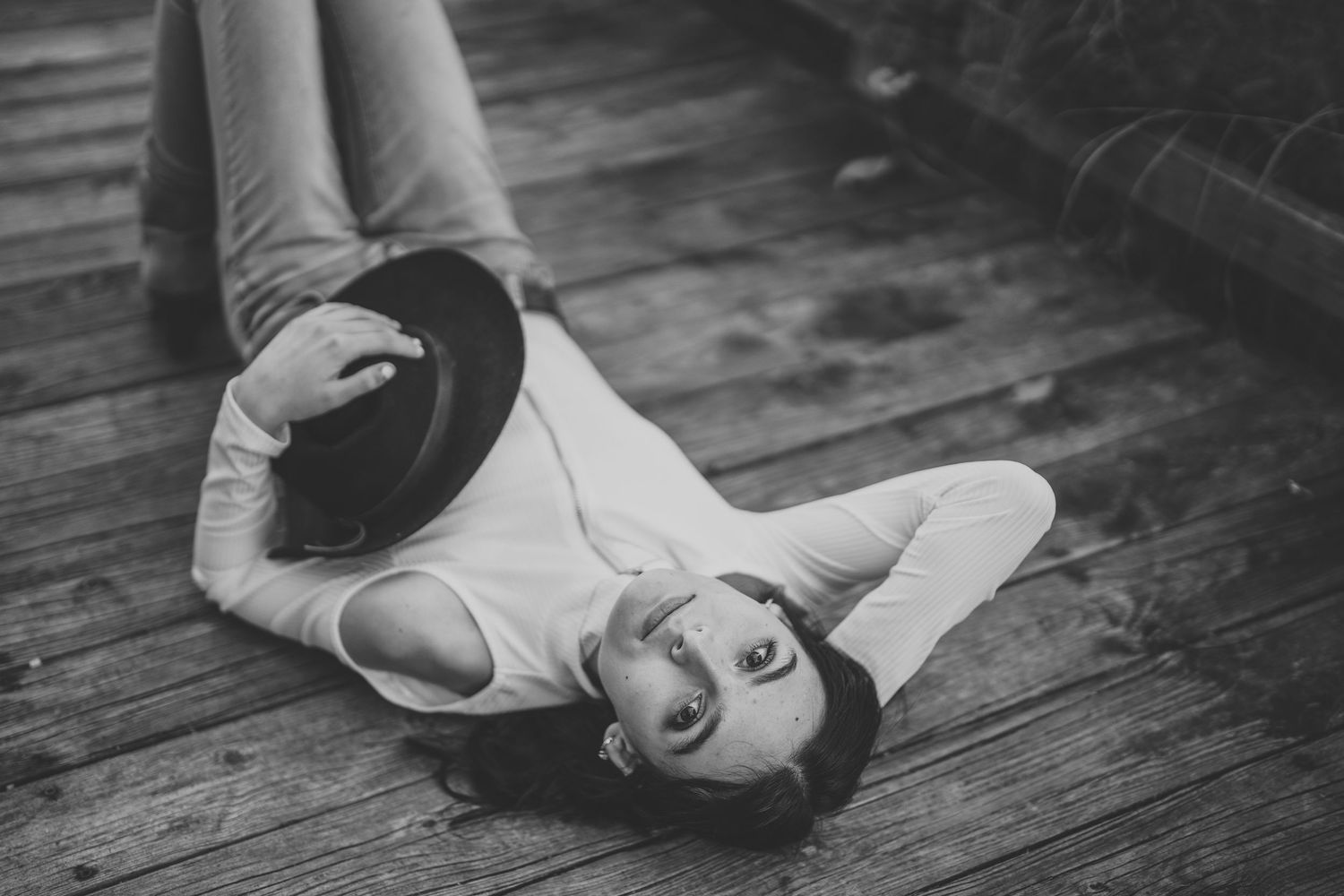 Black and white photo sequence showing a person lying down and rolling on wooden floorboards.