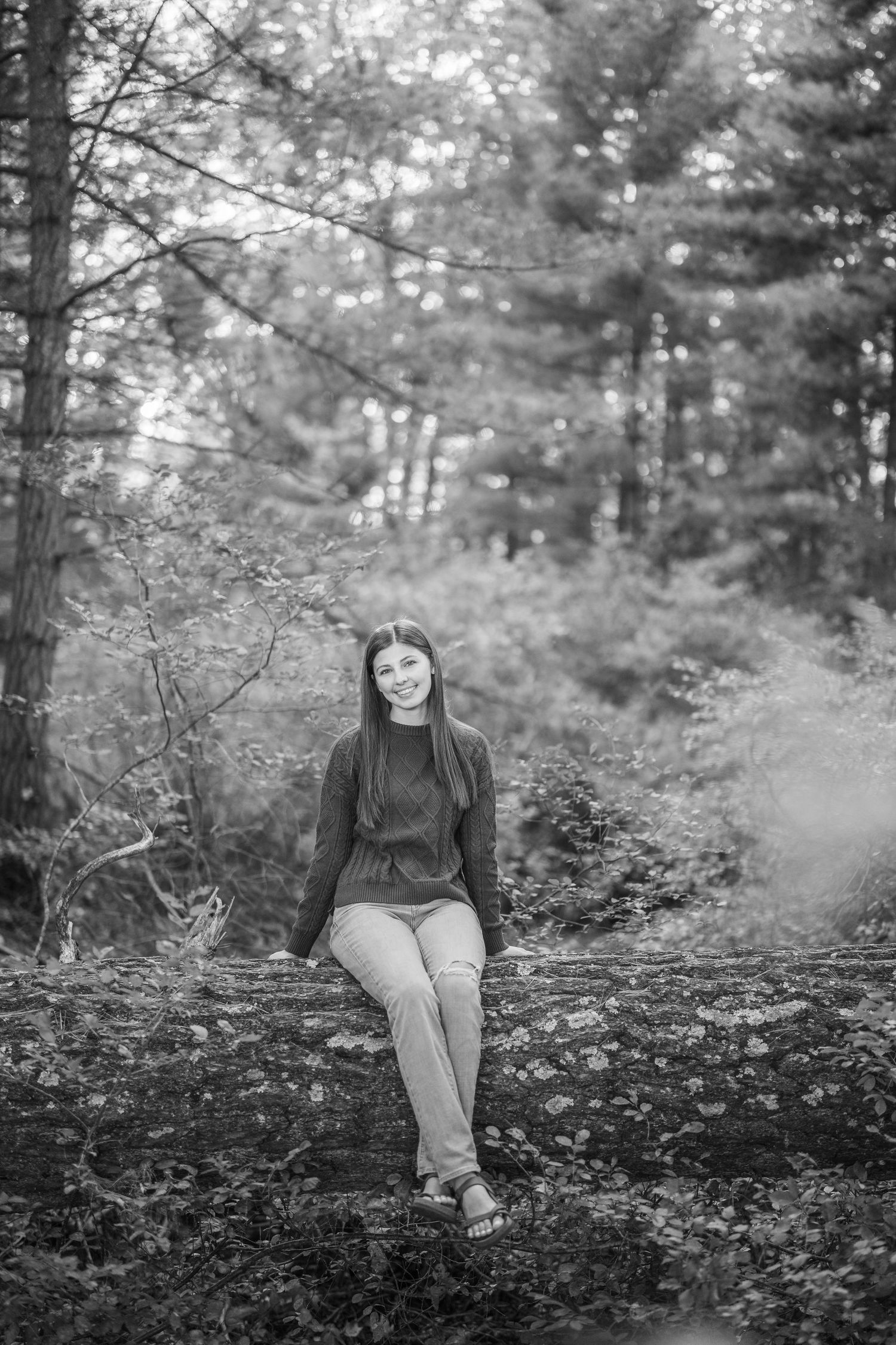 Black and white photo series showing a person sitting on fallen leaves in a wooded forest setting.