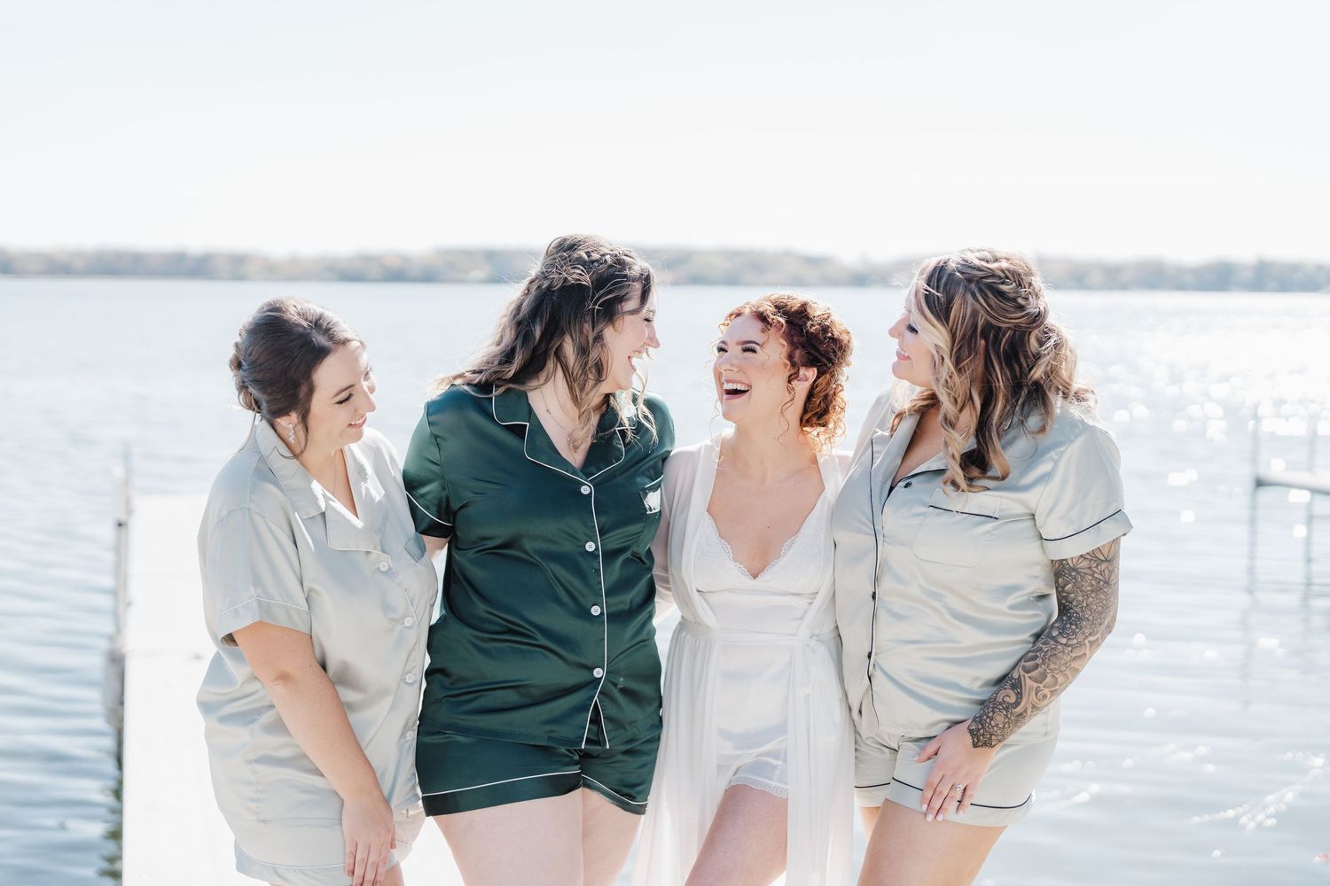 Group of friends laughing together by the waterfront in casual attire.
