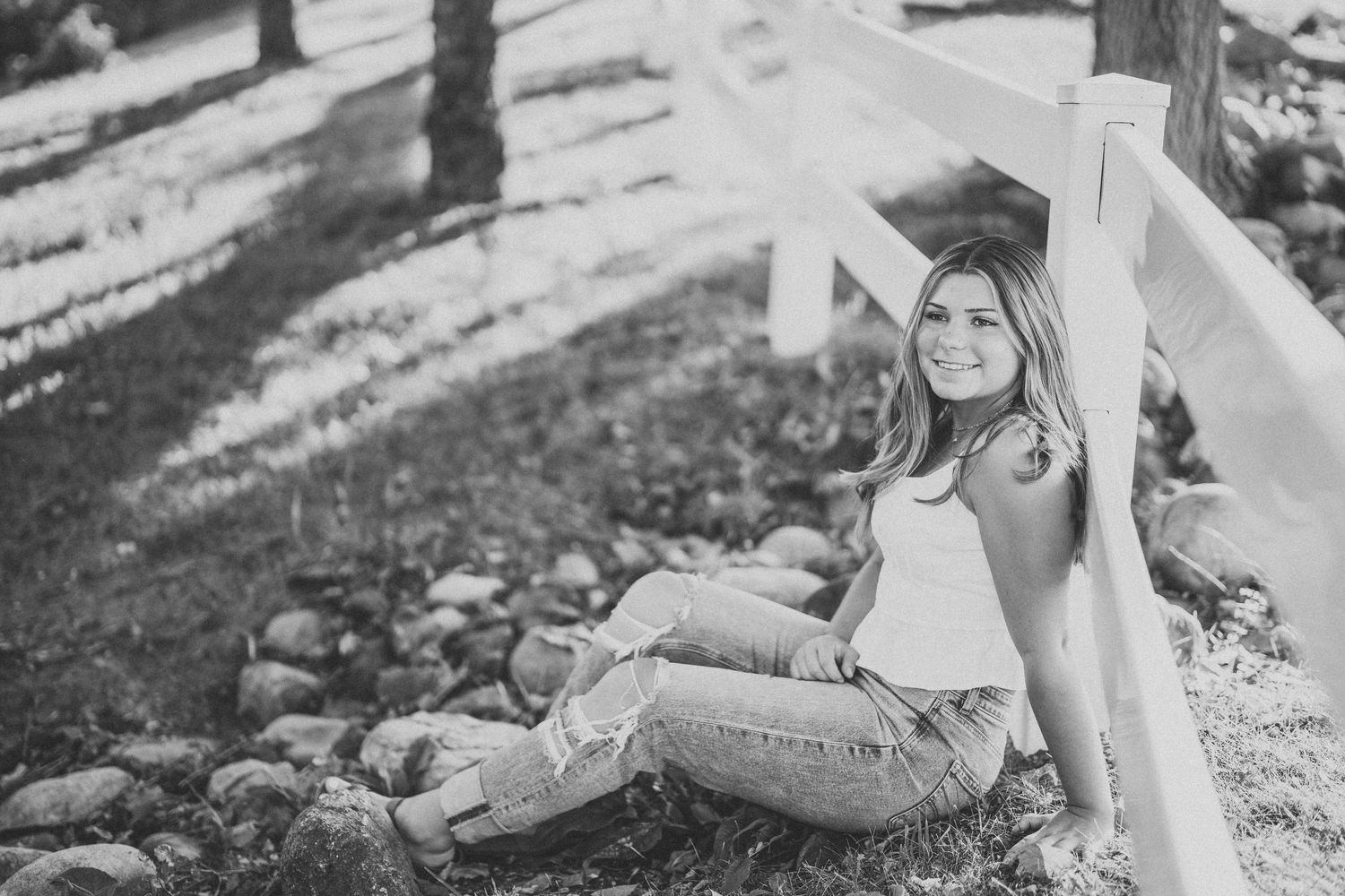 Black and white outdoor portrait with dramatic shadows and natural lighting.
