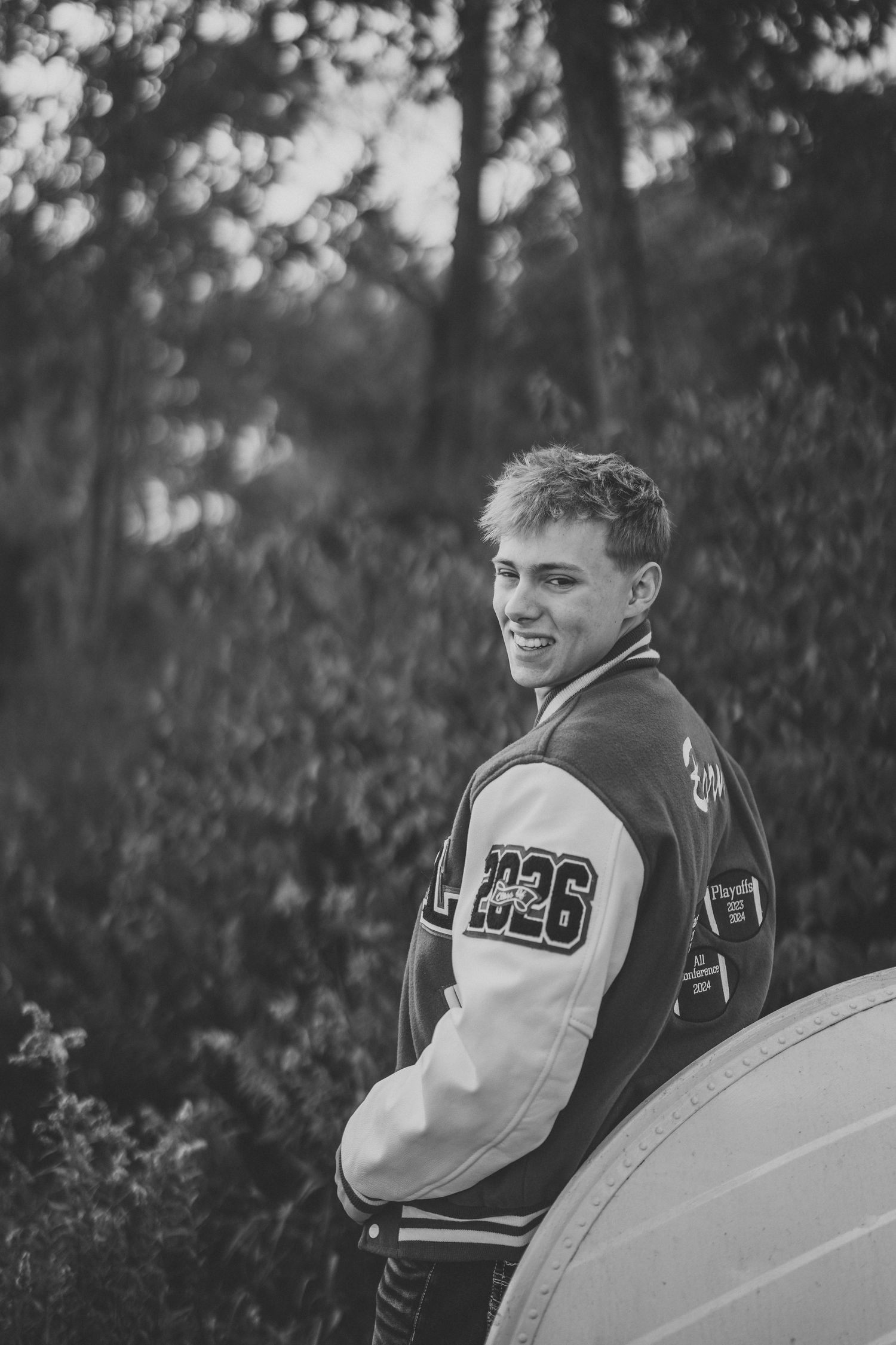 Black and white photos featuring someone in a varsity letterman jacket posing outdoors.