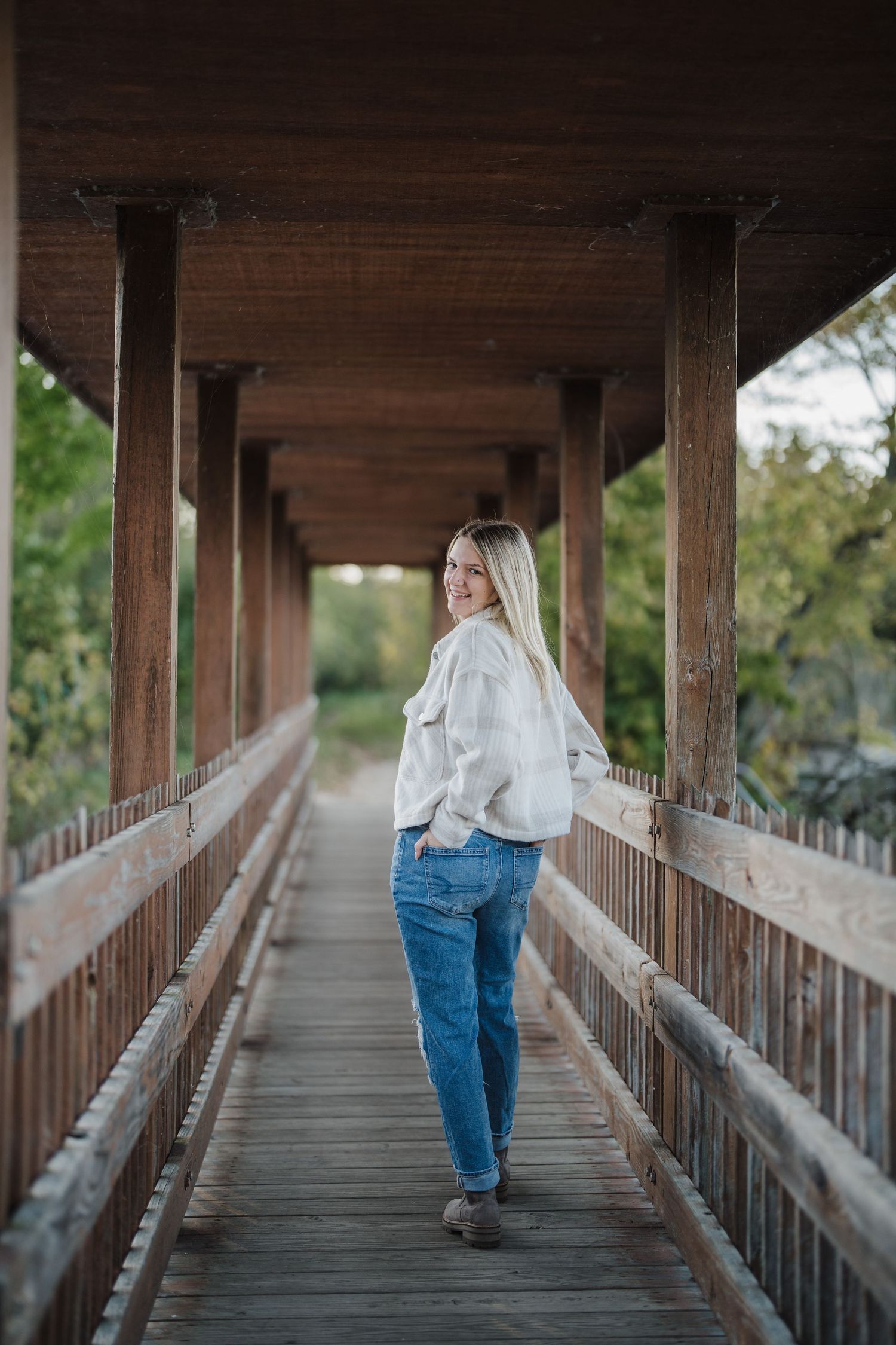 A sequence of photos showing someone walking away on a wooden covered bridge pathway.