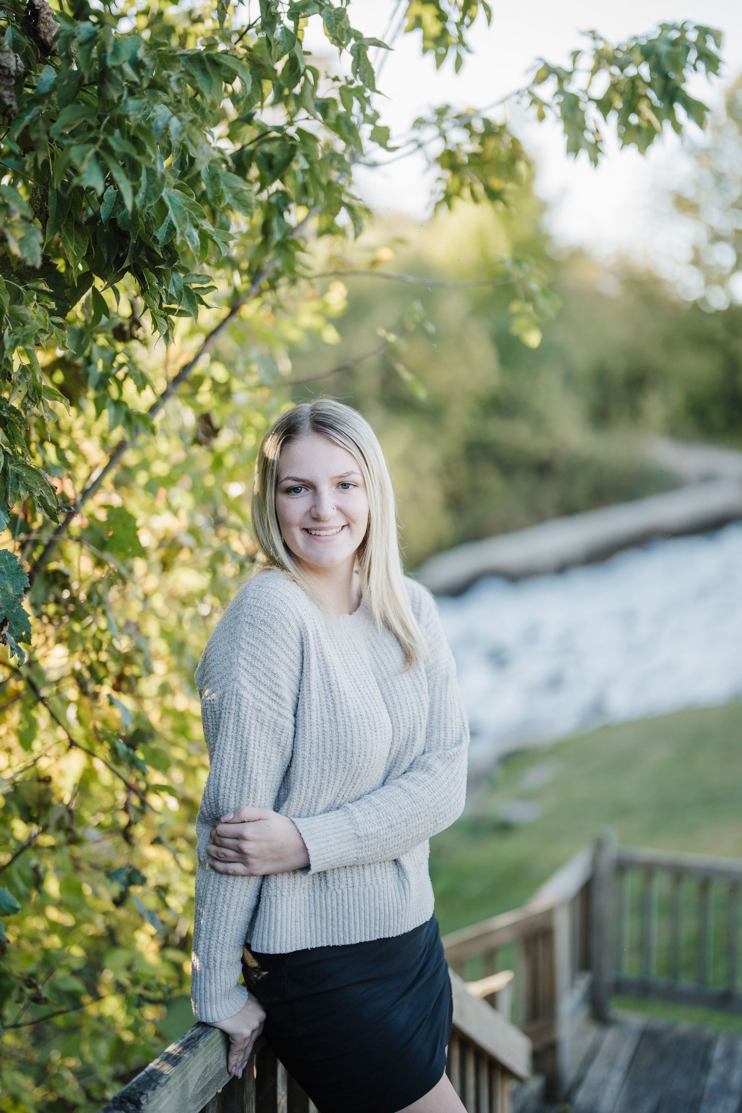 A series of outdoor portrait photos showing a person in a cozy gray sweater against a natural backdrop of green foliage.