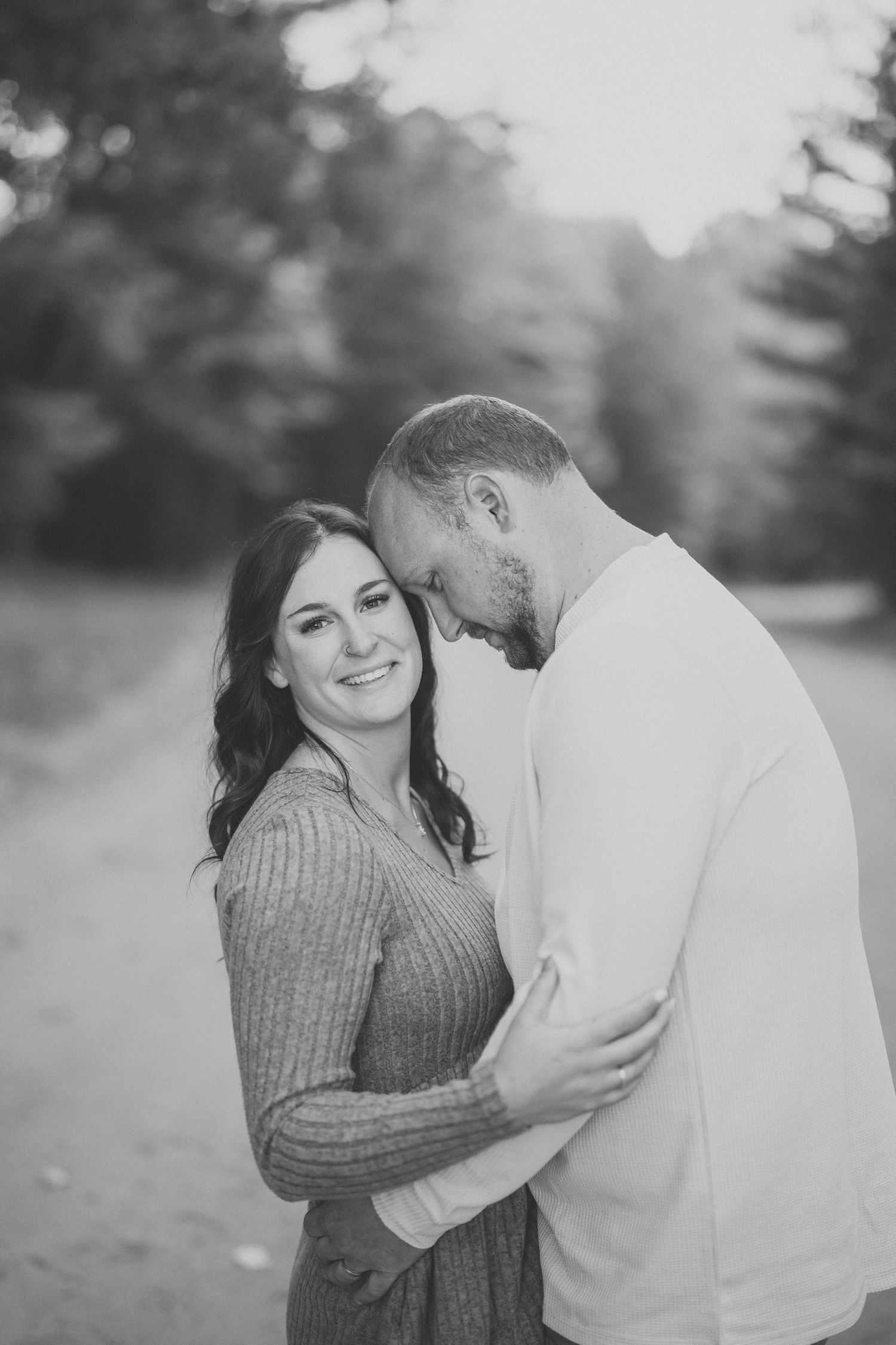 A couple in a romantic embrace share tender moments in a series of black and white outdoor photos.