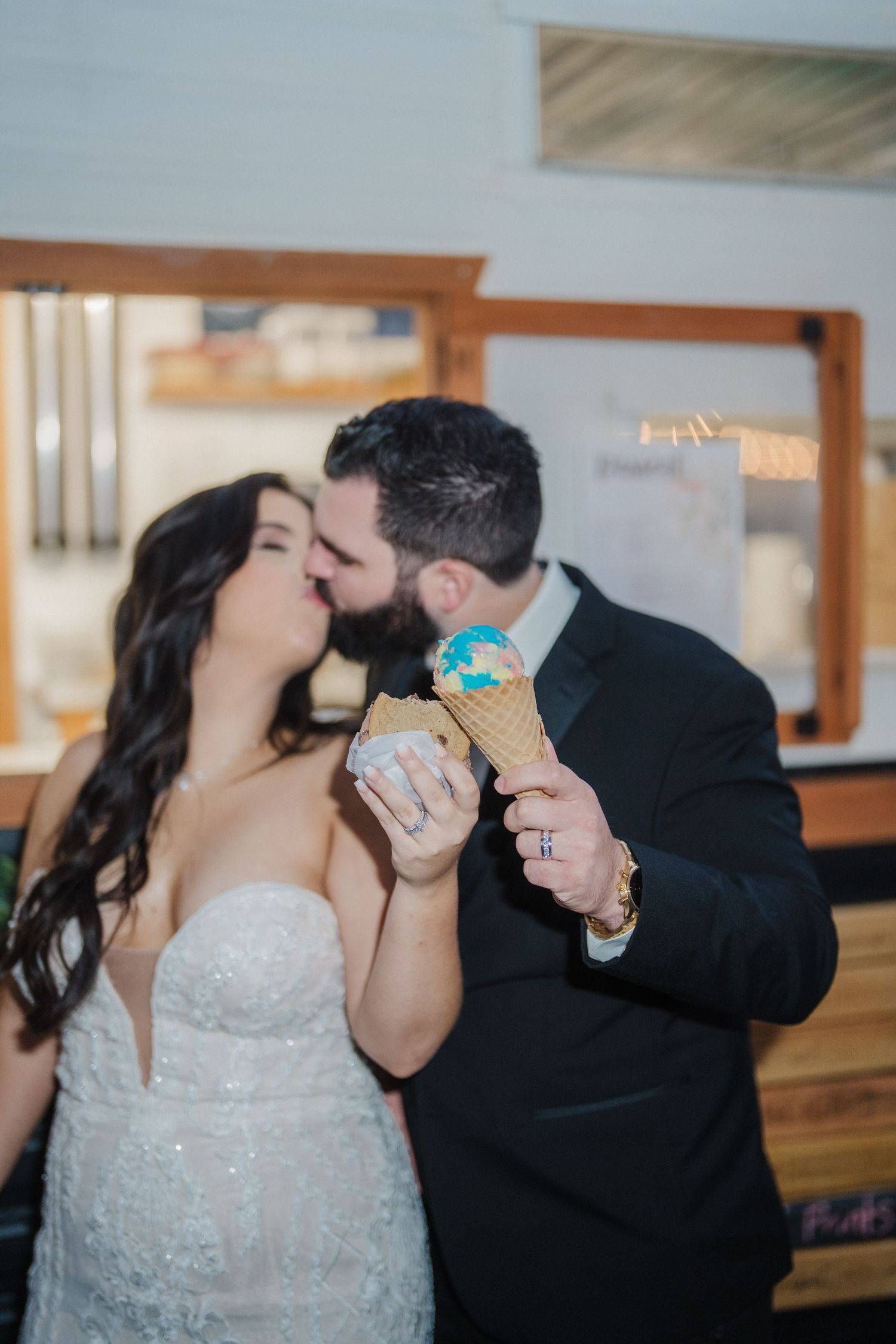 A couple shares drinks during their wedding celebration in an indoor venue.