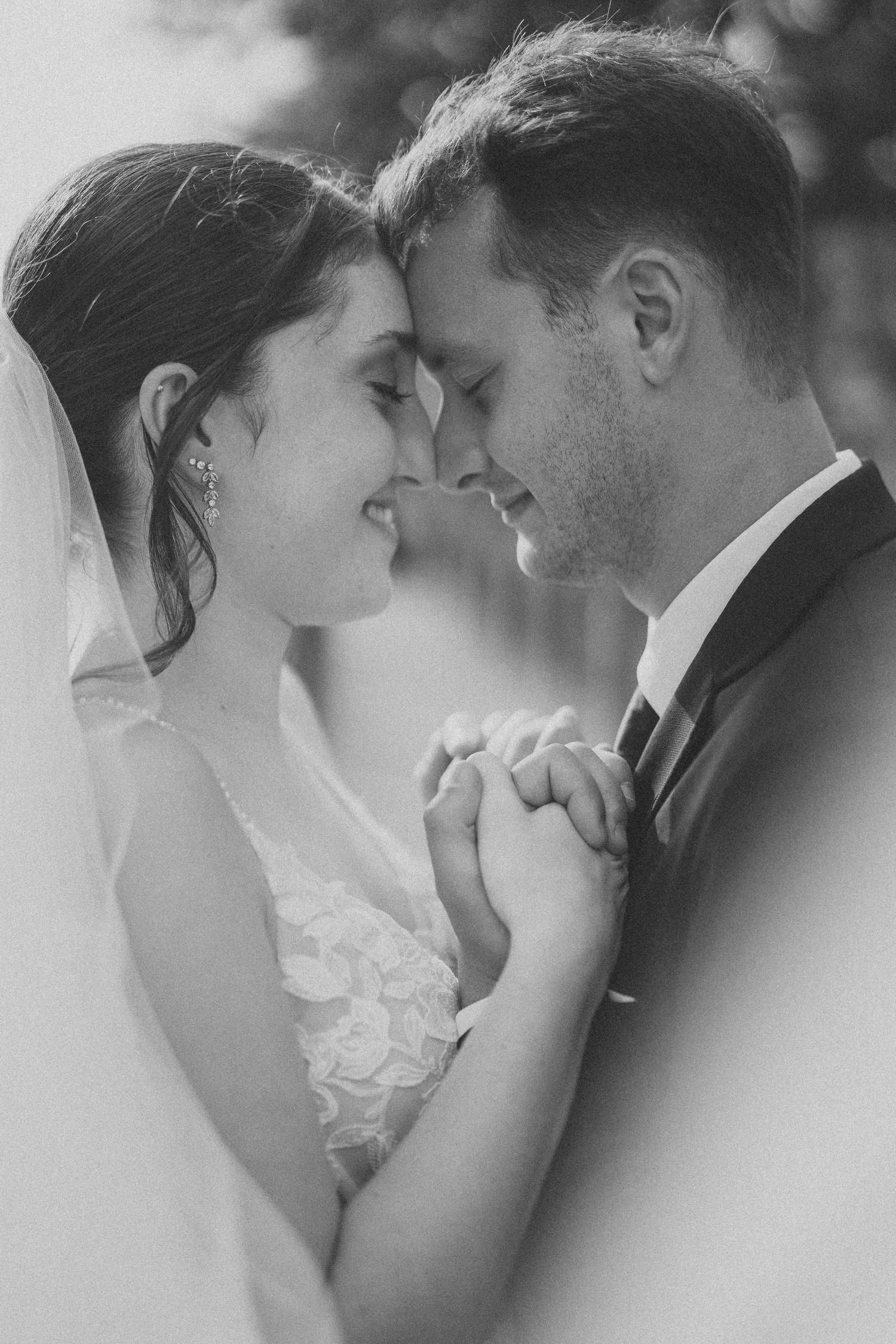 A romantic black and white photo series showing tender moments between a bride and groom on their wedding day.