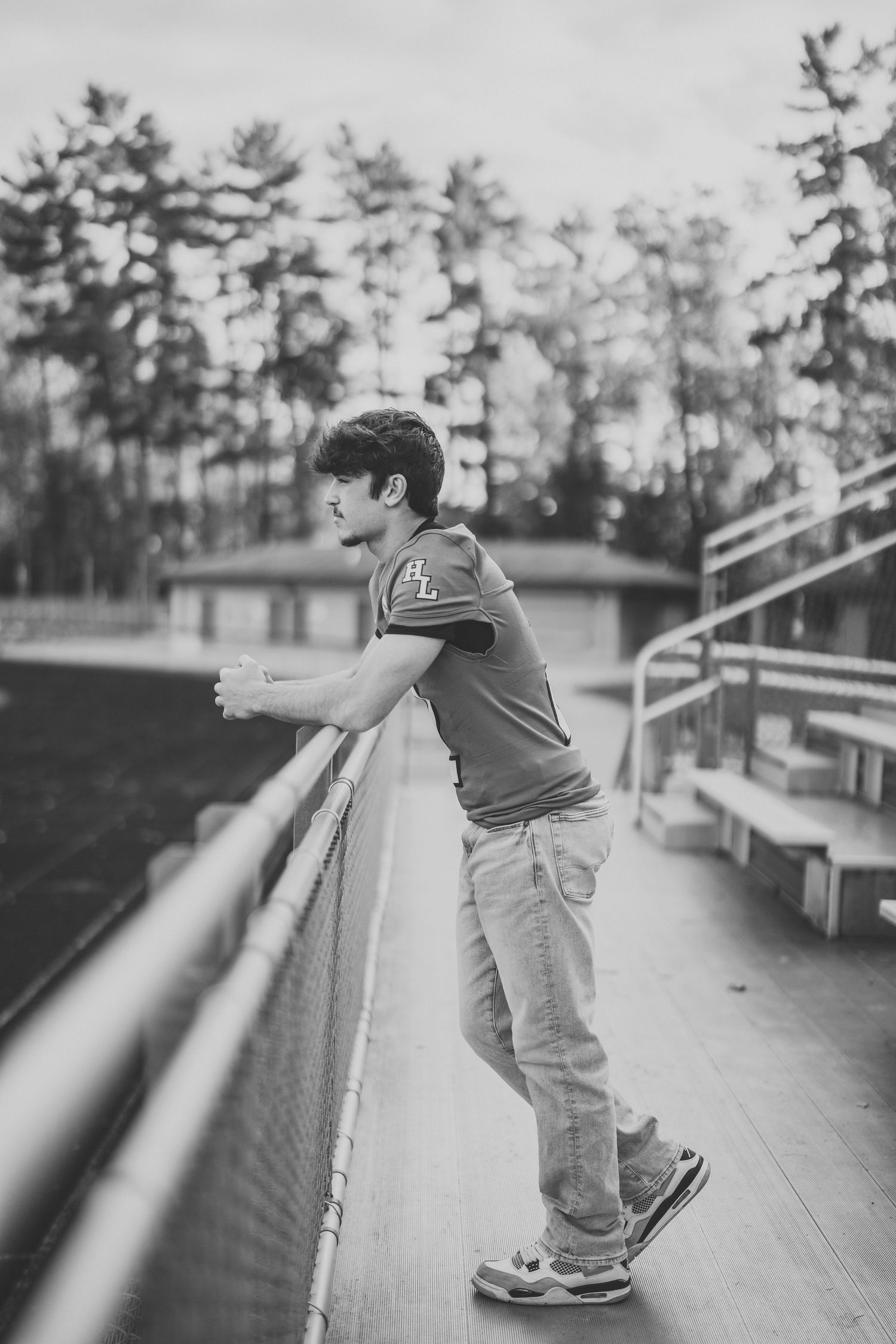 Black and white sequence showing a person sliding down stadium bleachers in casual attire.