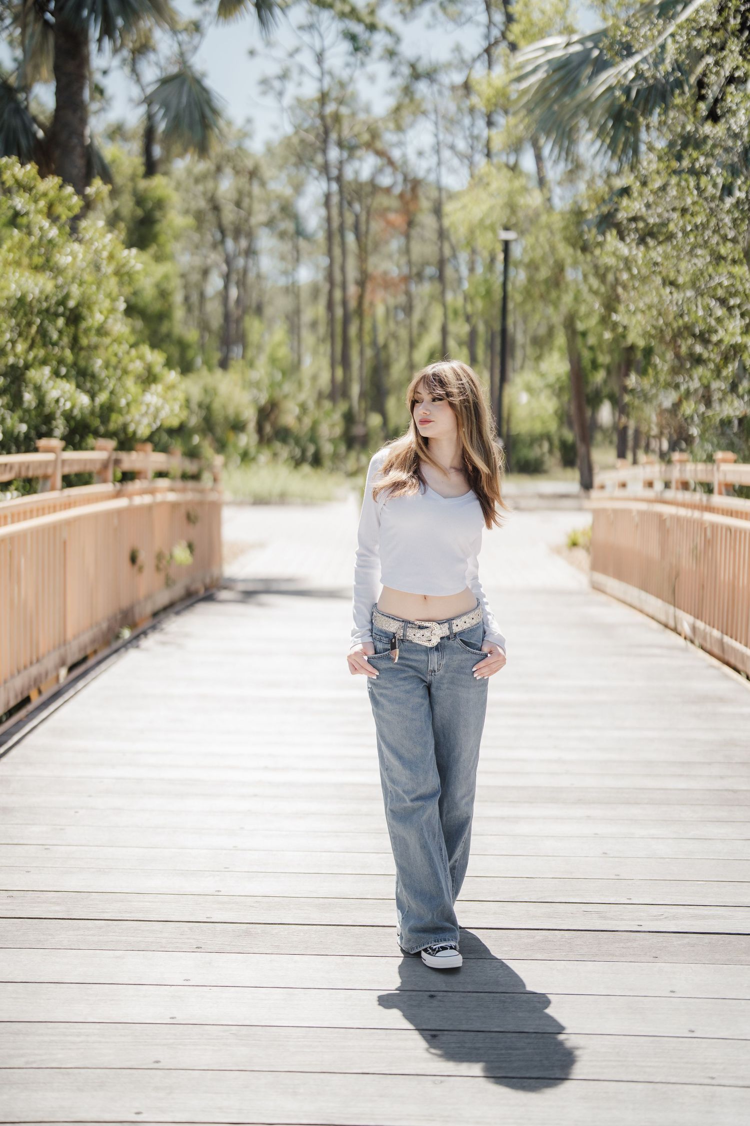 A series of photos showing someone walking away on a wooden boardwalk surrounded by trees and natural scenery.