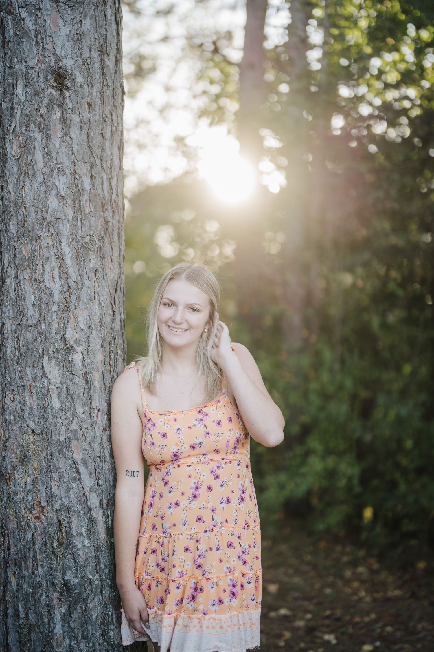 Sunlit outdoor portraits featuring a floral print top with trees and golden light filtering through the background.