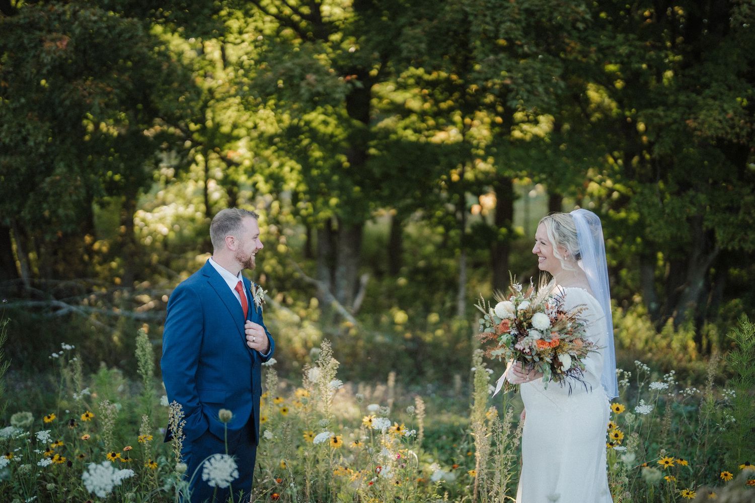 A couple shares a romantic moment in a sunlit garden setting during their wedding photoshoot.