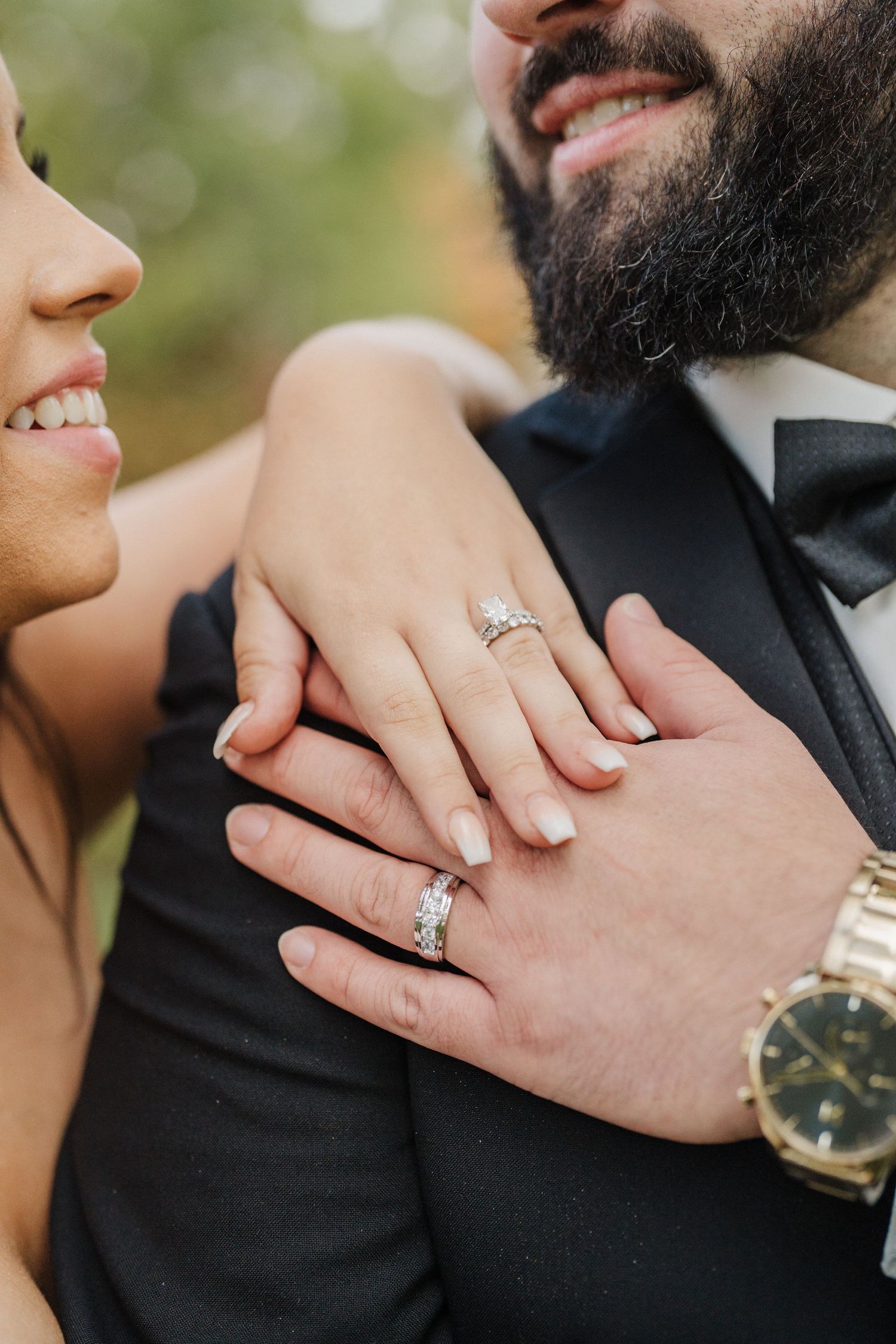 Close-up shots of hands showing wedding rings and jewelry against formal attire.