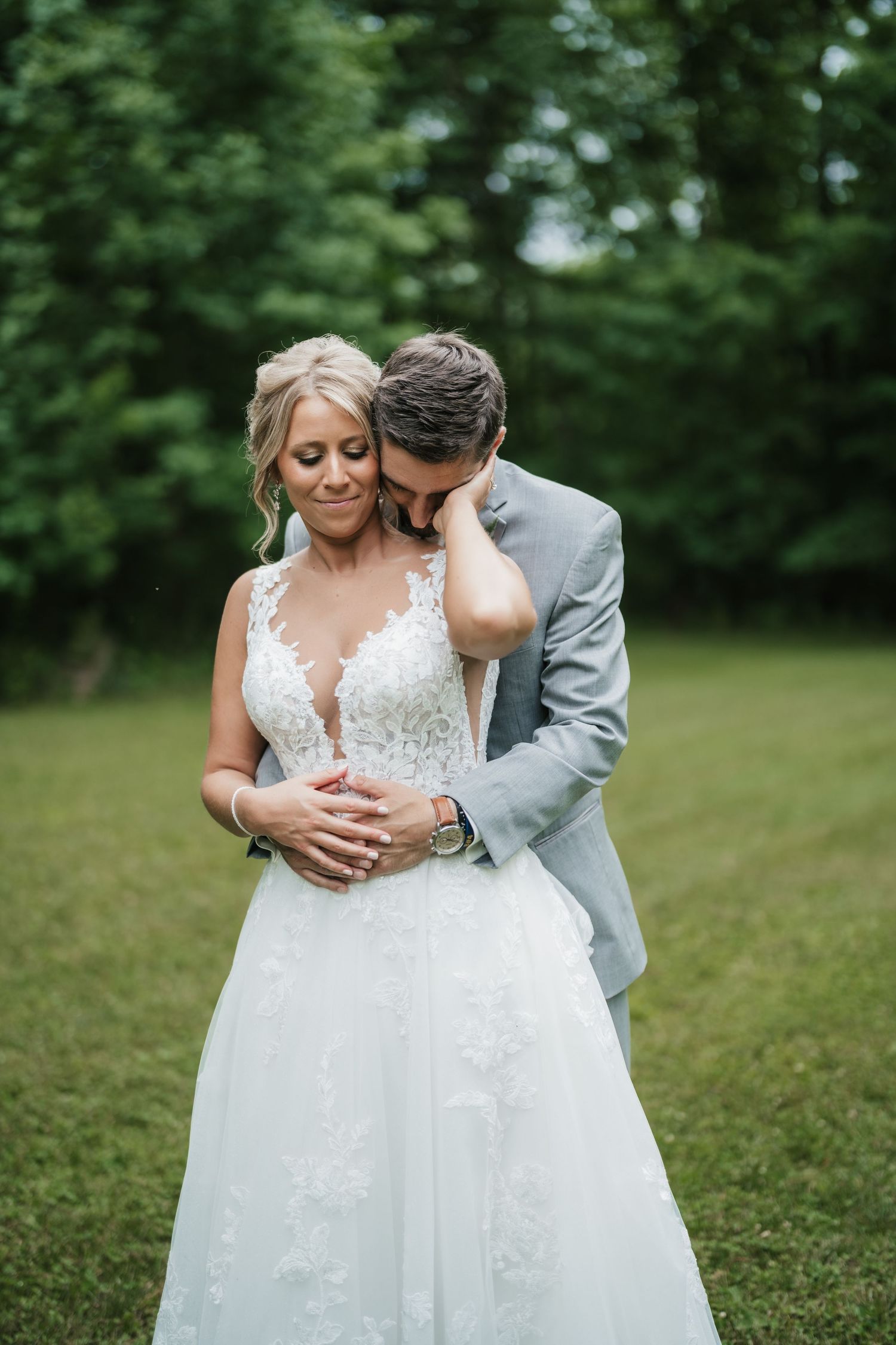 Romantic embrace between newlyweds during outdoor wedding photography session.