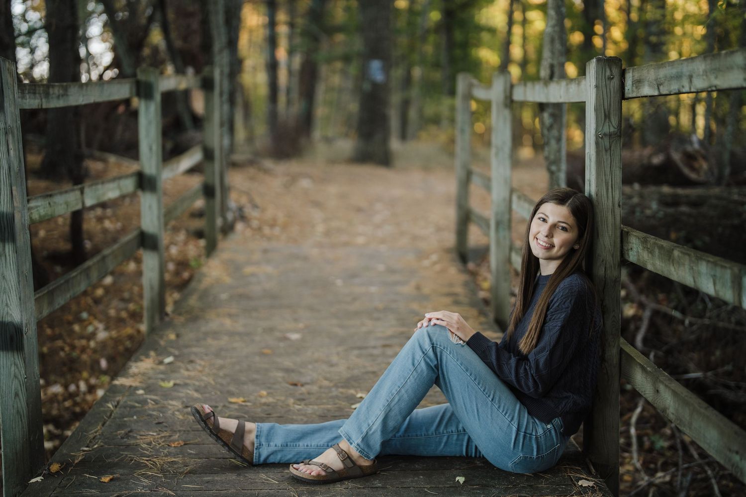 A series of outdoor portraits showing someone posing casually along a wooden fence in autumn scenery.