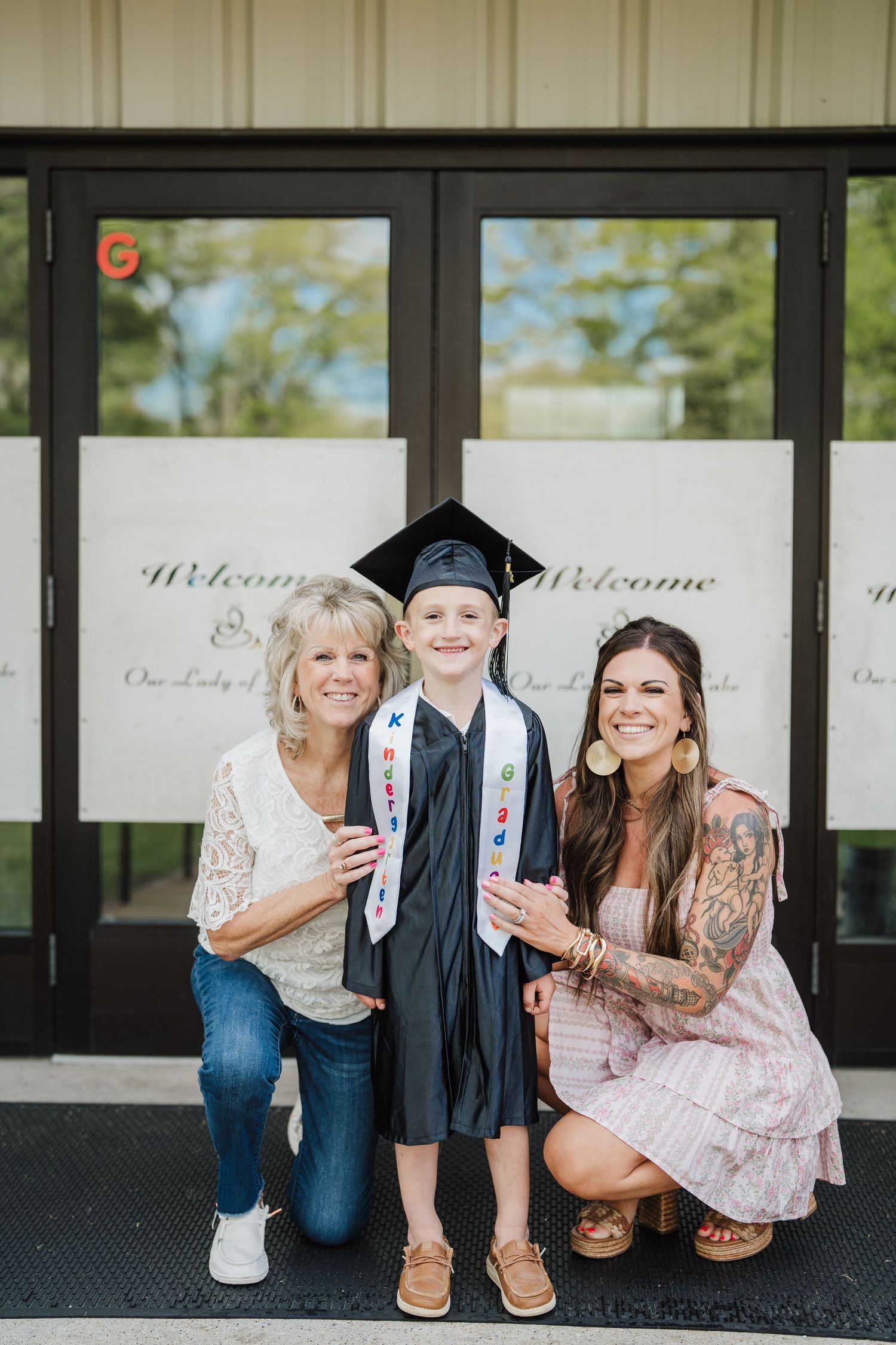 Group photo session with graduation cap and casual attire against a decorative backdrop.