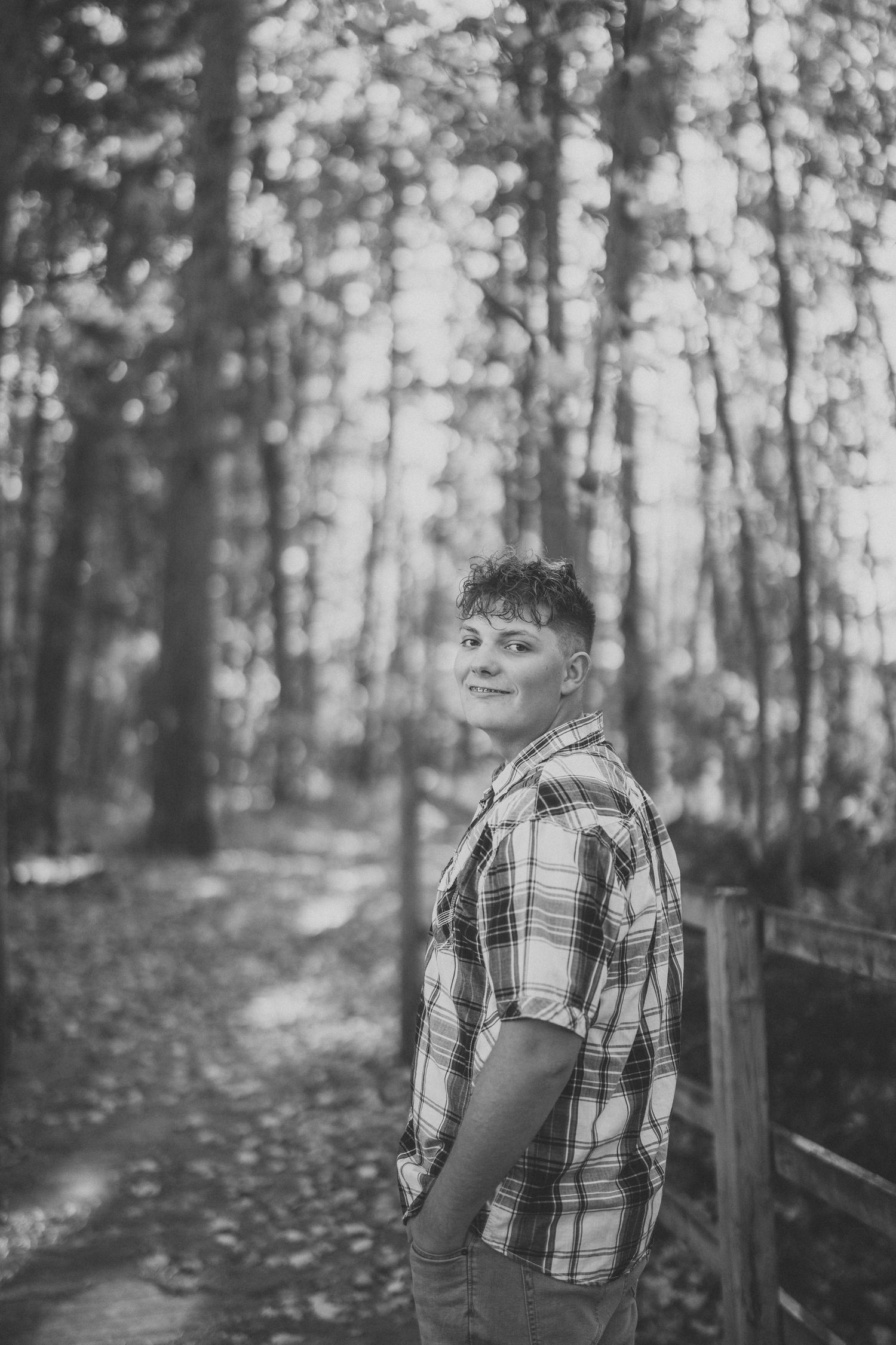 Black and white photo series of a person walking through a misty forest path wearing a plaid shirt.