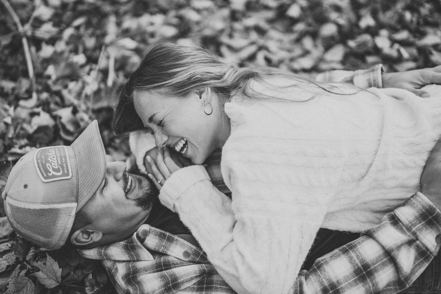 Black and white photo collage showing romantic couple lying in autumn leaves during an outdoor photo session.
