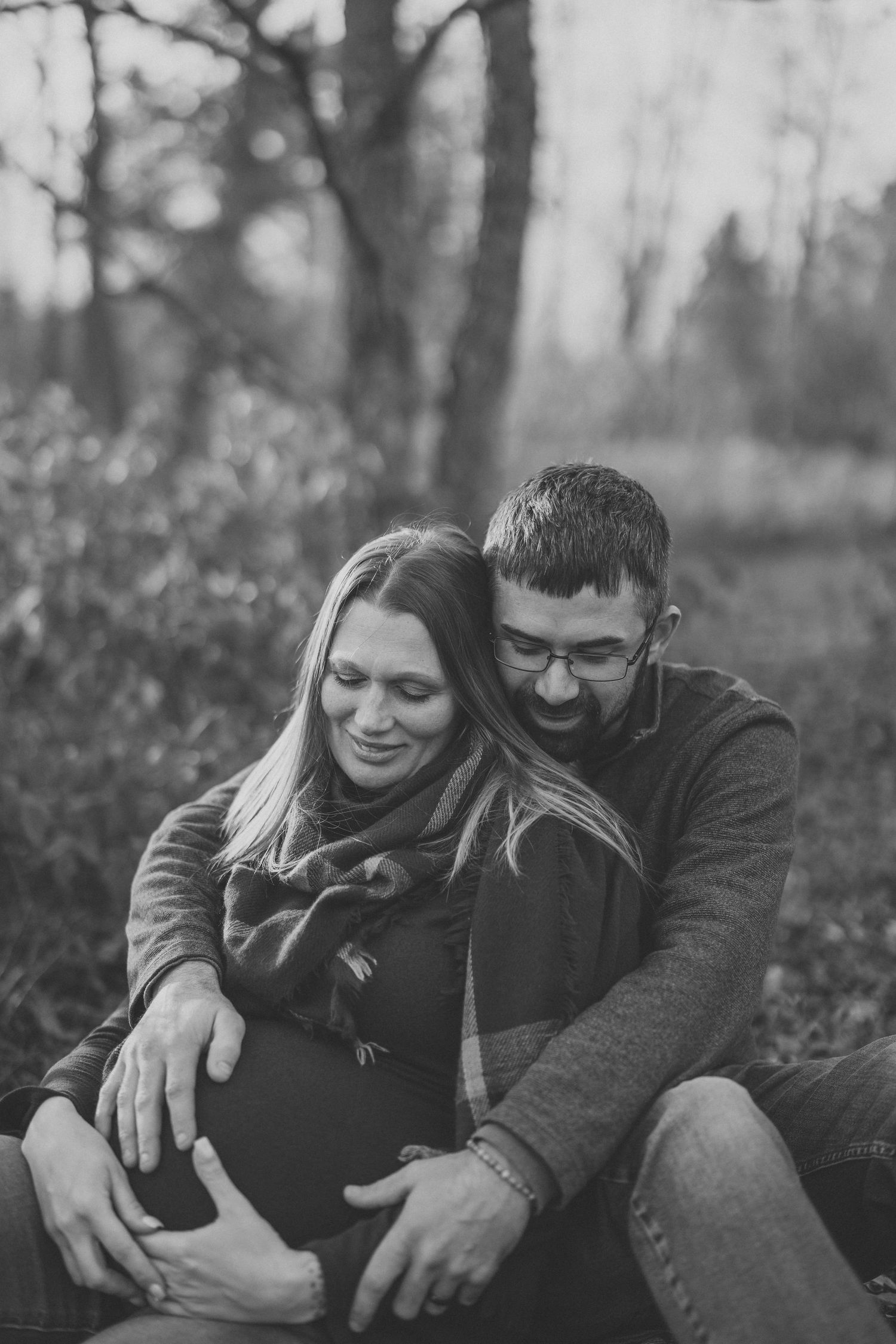 A couple shares intimate moments in a black and white photo series set against a natural outdoor backdrop.